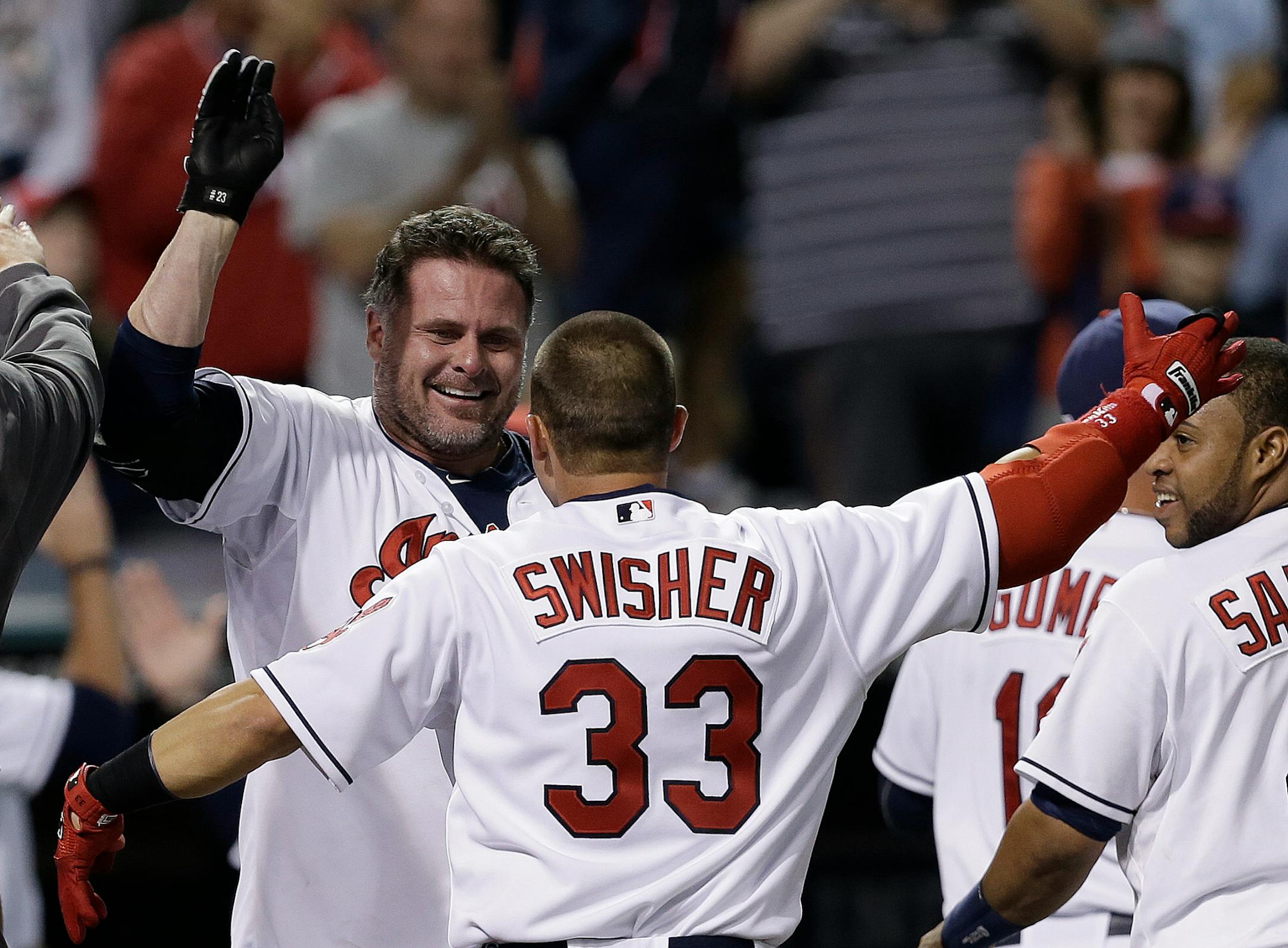The Cleveland Indians' Jason Giambi, back celebrated with Nick Swisher after Giambi hit a game-winning home run off Chicago White Sox relief pitcher Ramon Troncoso in the ninth inning Monday in Cleveland. The Indians won 3-2.