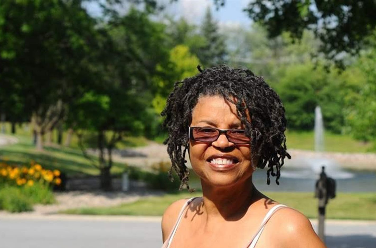 Sandra Finley outside her home in Olympia Fields, Illinois, with a nearby fountain that inspires her. "Peace is here. Beauty is here. Let me tell you what peace adds to your life &#x2014; it opens up a whole section of capacity in your brain." (The Pew Charitable Trusts/TNS)