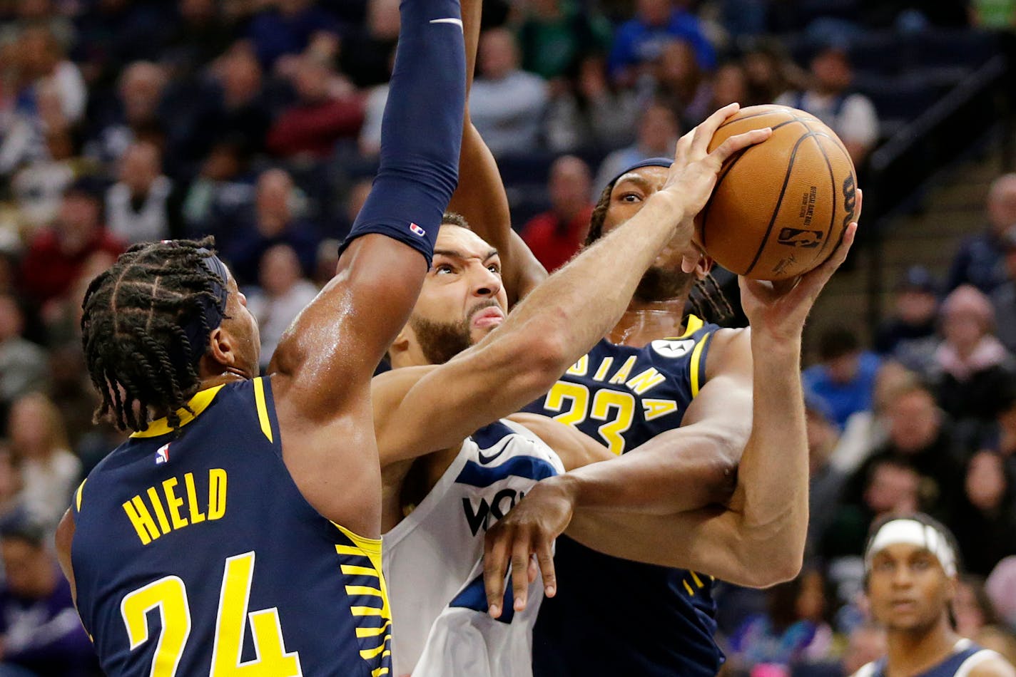 Minnesota Timberwolves center Rudy Gobert (27) shoots between Indiana Pacers guard Buddy Hield (24) and center Myles Turner (33) during the second quarter of an NBA basketball game Wednesday, Dec. 7, 2022, in Minneapolis. (AP Photo/Andy Clayton-King)