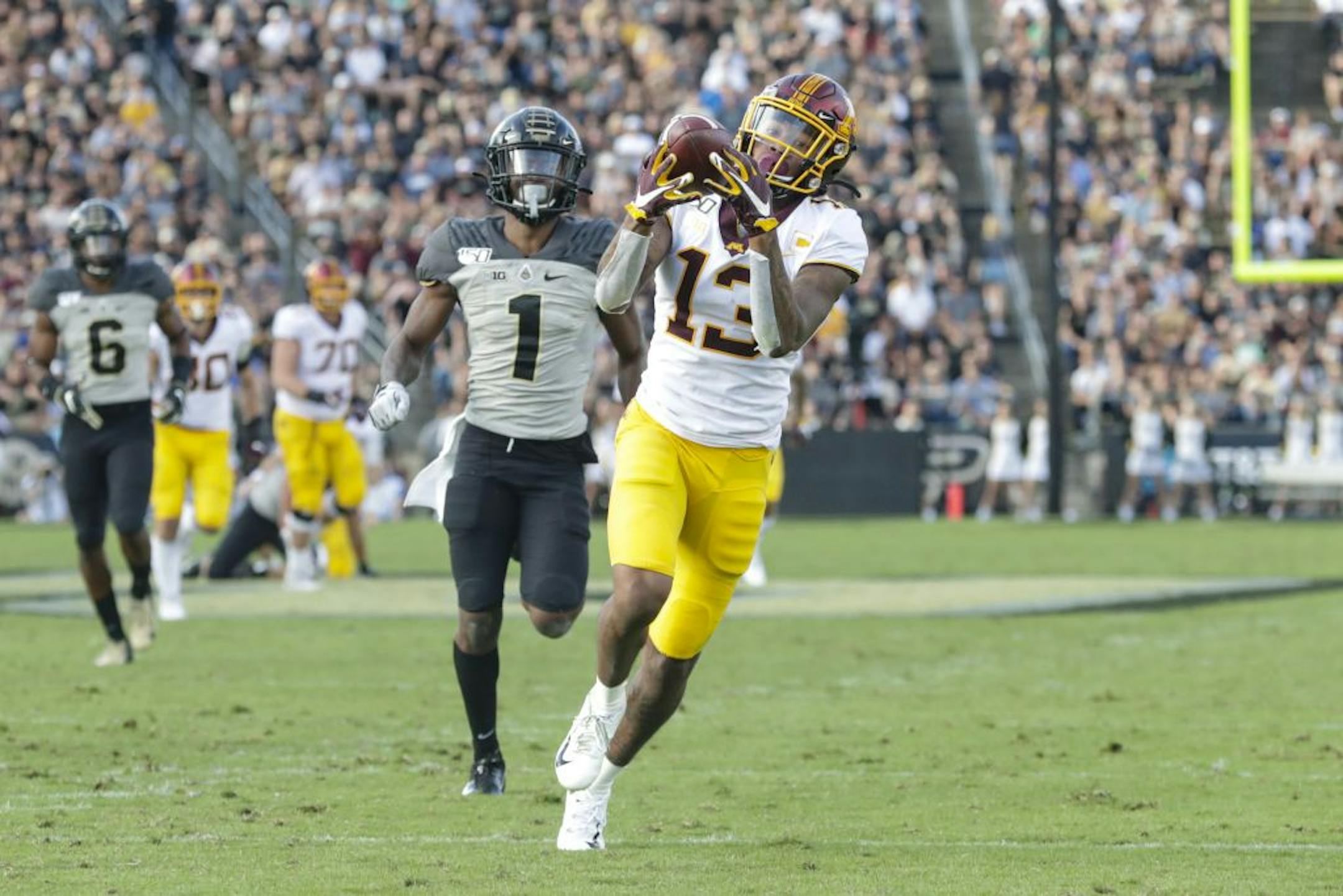 Minnesota wide receiver Rashod Bateman (13) makes a catch in front of Purdue cornerback Dedrick Mackey (1) on his way to a touchdown during the second half of an NCAA college football game in West Lafayette, Ind., Saturday, Sept. 28, 2019. Minnesota defeated Purdue 38-31.