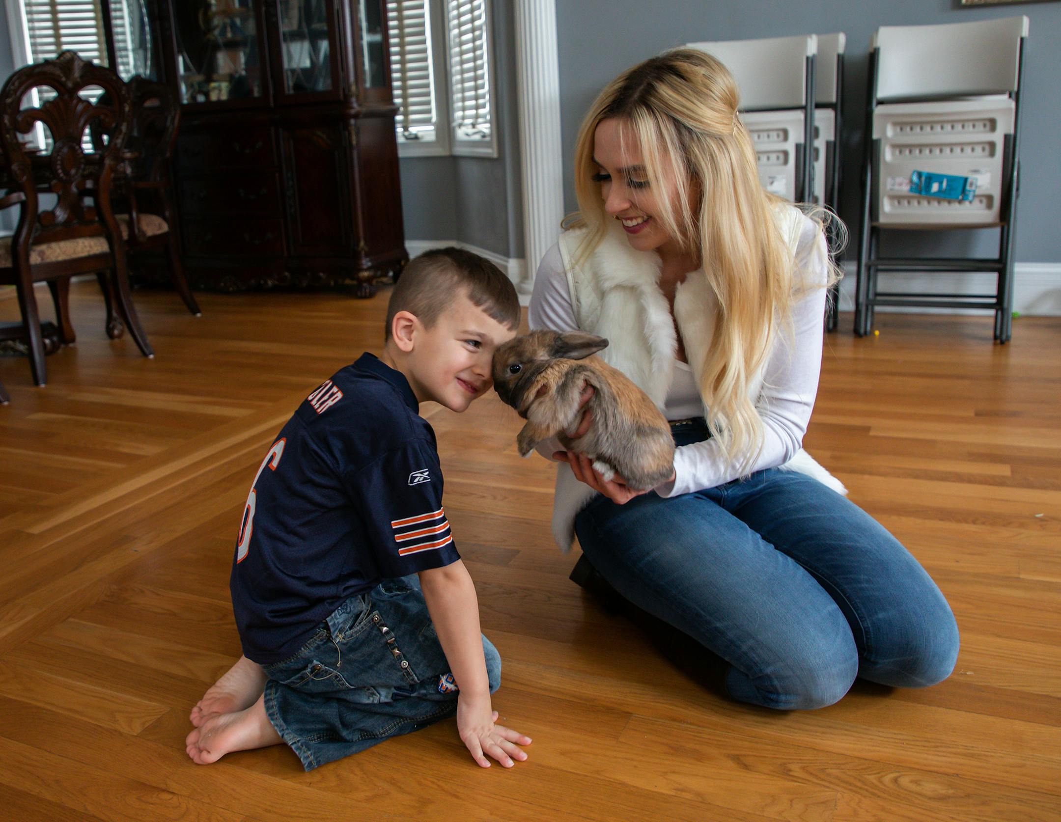 Daniel Rafati, 5, and his mother, Lisa Wilkie, play with their pet rabbit Baby Bun Bun at home in Frankfort on Jan. 28, 2019. (Zbigniew Bzdak/Chicago Tribune/TNS)