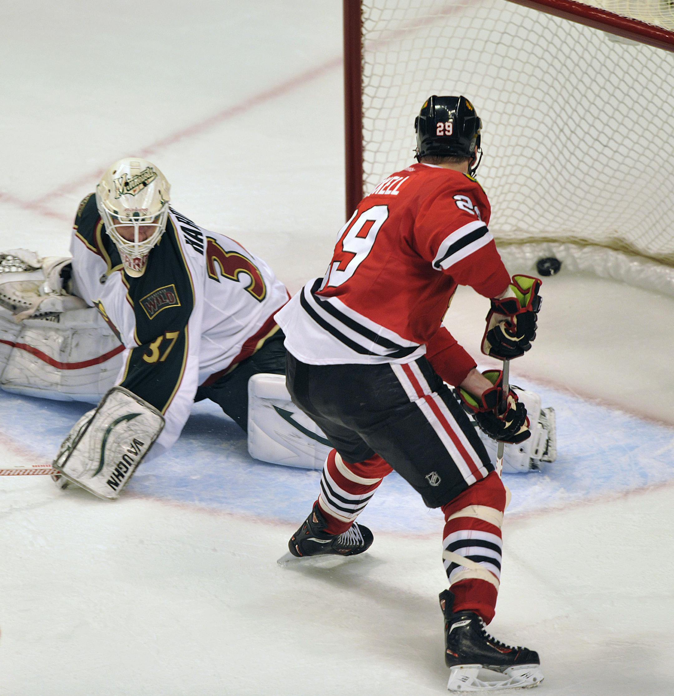 Chicago Blackhawks' Bryan Bickell right, shoots the game-winning goal past Minnesota Wild's Josh Harding during the overtime period of Game 1 of an NHL hockey Stanley Cup playoff series Tuesday, April 30, 2013, in Chicago. The Blackhawks defeated the Wild 2-1. (AP Photo/Jim Prisching)