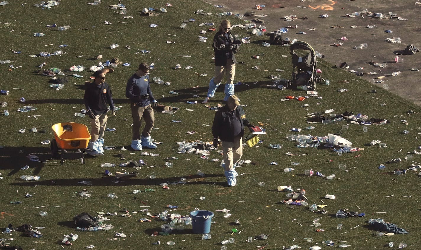 Investigators walk through debris on festival grounds across the street from the Mandalay Bay Resort and Casino after Sunday's mass shooting in Las Vegas.