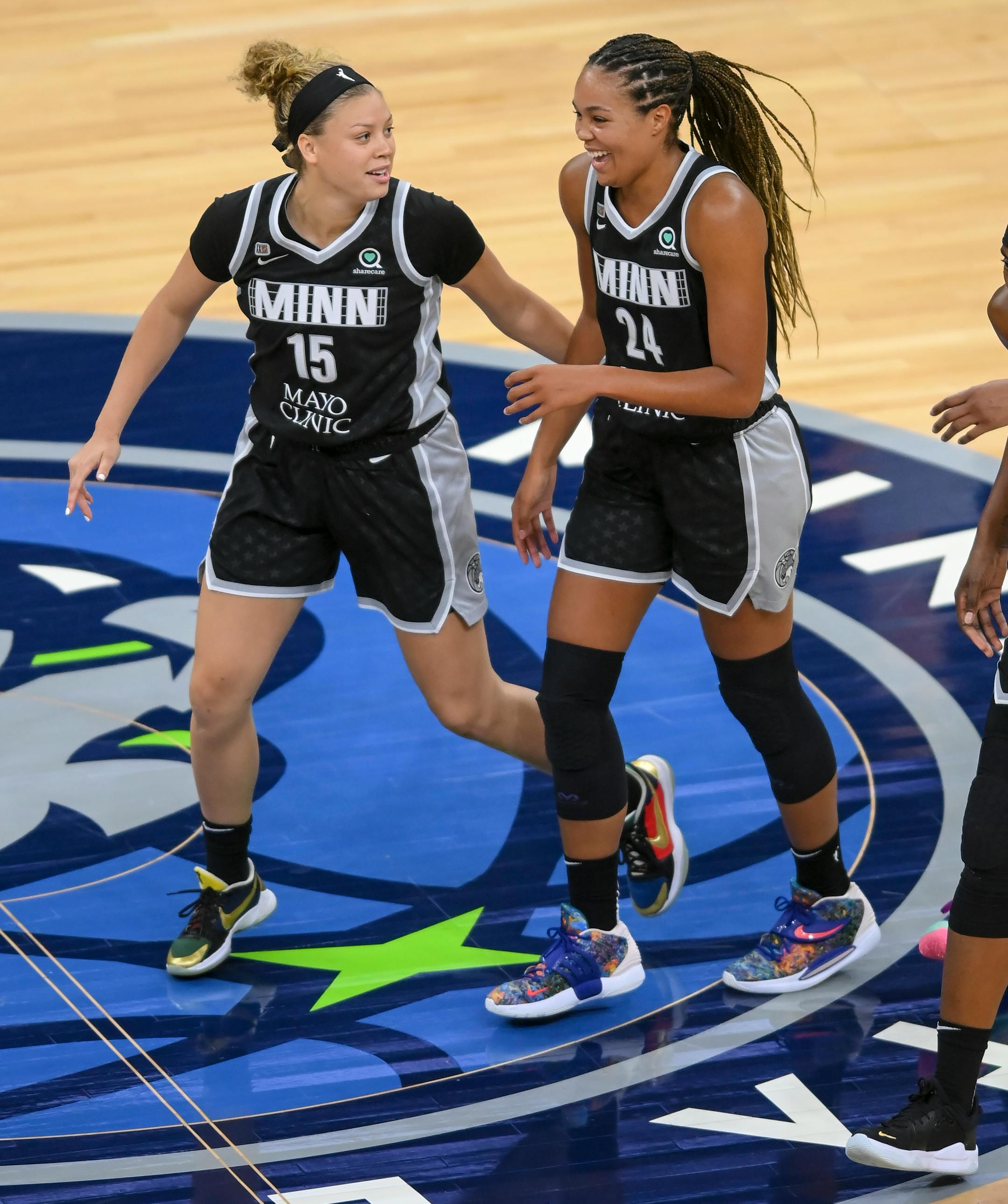 Minnesota Lynx guard Rachel Banham (15) and forward Napheesa Collier (24) celebrated as they ran back to the sideline after forcing a timeout in the second half against the Dallas Wings.