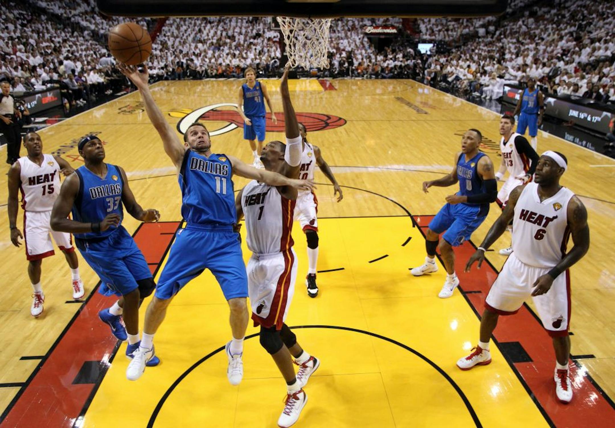 Dallas Mavericks' Jose Juan Barea (11) goes up for a shot against Miami Heat's Chris Bosh (1) during the first half of Game 2 of the NBA Finals basketball game Thursday, June 2, 2011, in Miami.