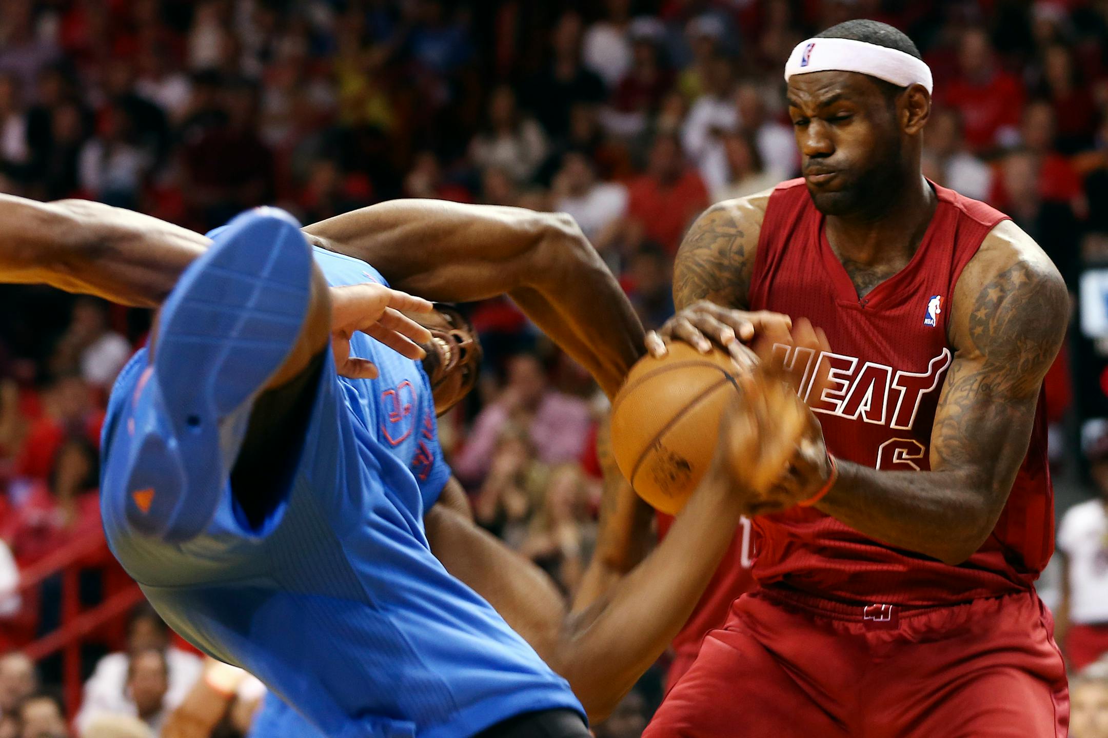 Oklahoma City Thunder's Serge Ibaka (9) and Miami Heat's LeBron James (6) battle for the ball.