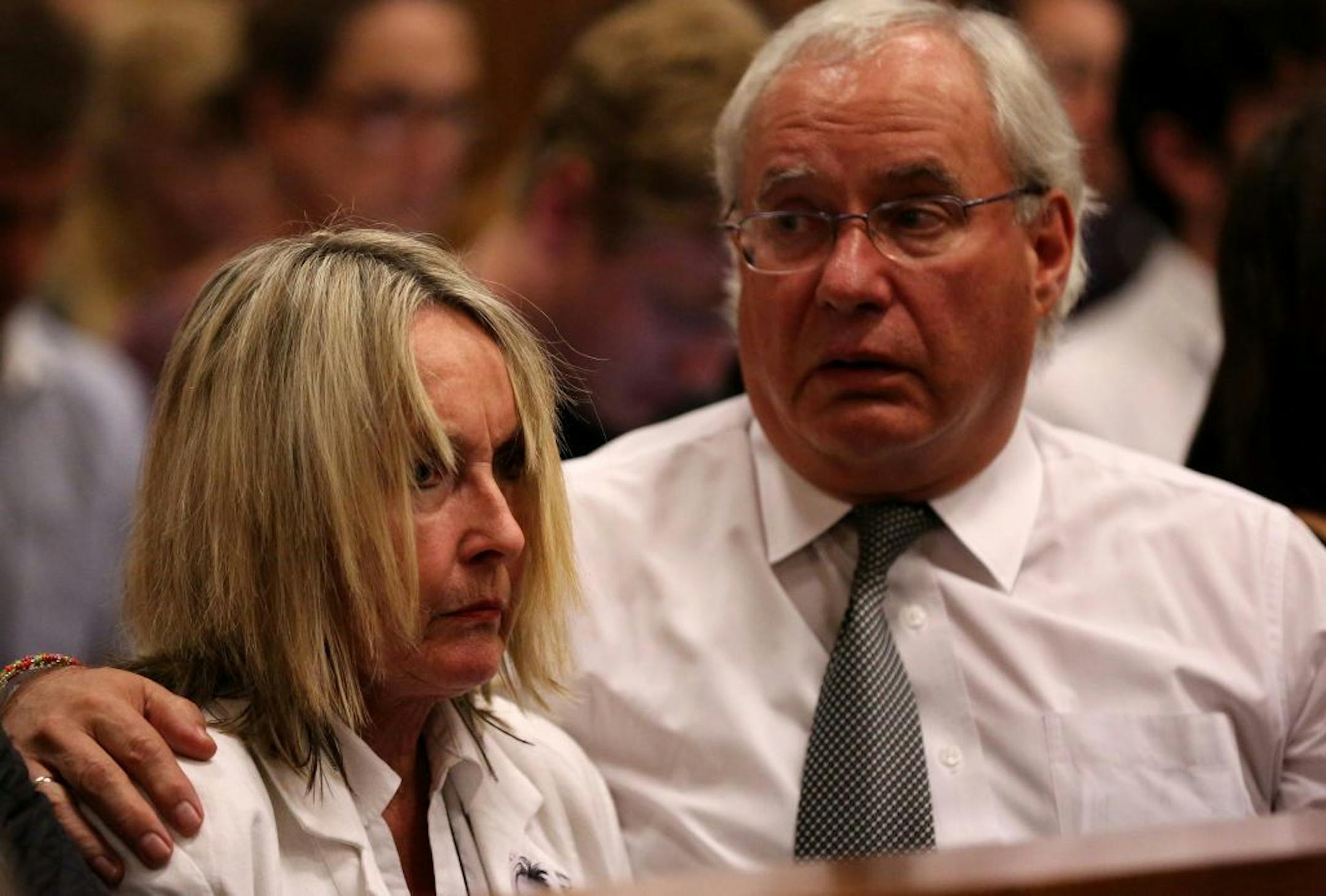 Mother of the late Reeva Steenkamp, June Steenkamp, left, is comforted by family lawyer Dup de Bruyn, as they listen to cross questioning of Oscar Pistorius, in court in Pretoria, South Africa, Wednesday, April 9, 2014.