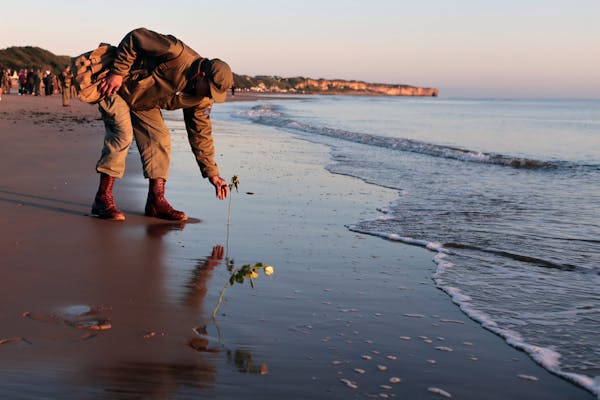 World War II reenactor put roses and flowers at dawn on Omaha Beach, in Saint-Laurent-sur-Mer, Normandy, France Monday, June 6, 2022, the day of 78th 