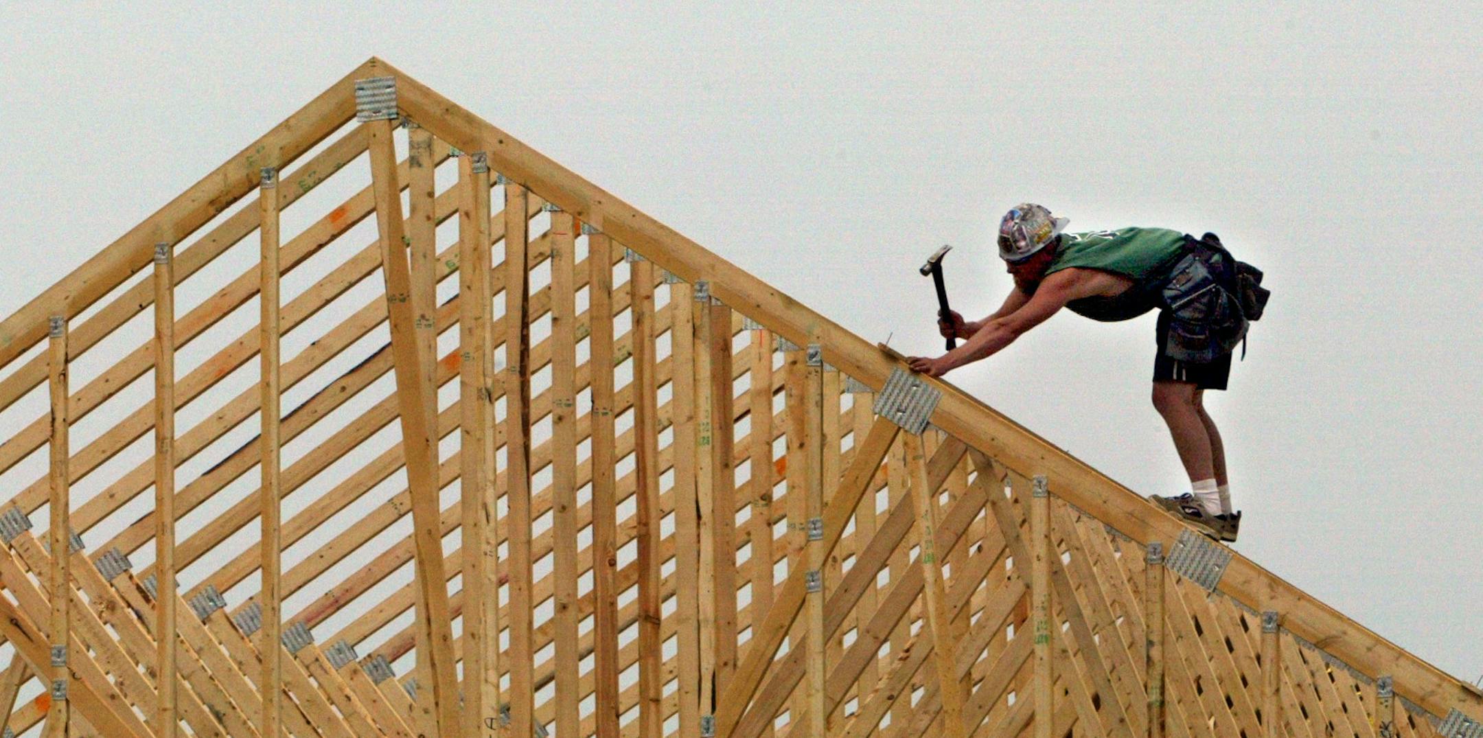 Zach Hunter frames a roof on a new home under construction in Lakeville.