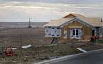 A crude oil drill rig stands in the distance of a single-family home under construction in Williston, North Dakota, U.S., on Monday, Feb. 13, 2012. Th