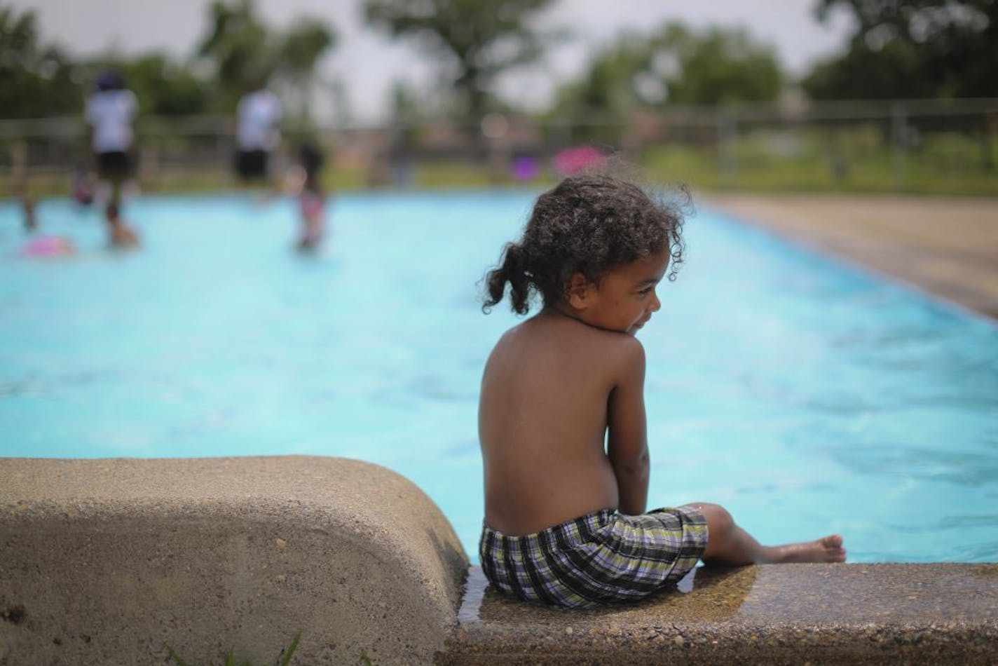 Two-year-old Shaun Johnson played at the pool by his house on Friday, June 29, 2012 in Minneapolis, Minn., a few blocks from where a 5-year-old boy was shot asleep on the couch in his house. Johnson's mom said the shooting was close to home having a young son.