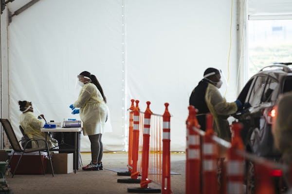 Workers administer drive-thru coronavirus tests at a testing site in Milwaukee, Nov. 5, 2020. Republican attorneys general in 18 states and the admini