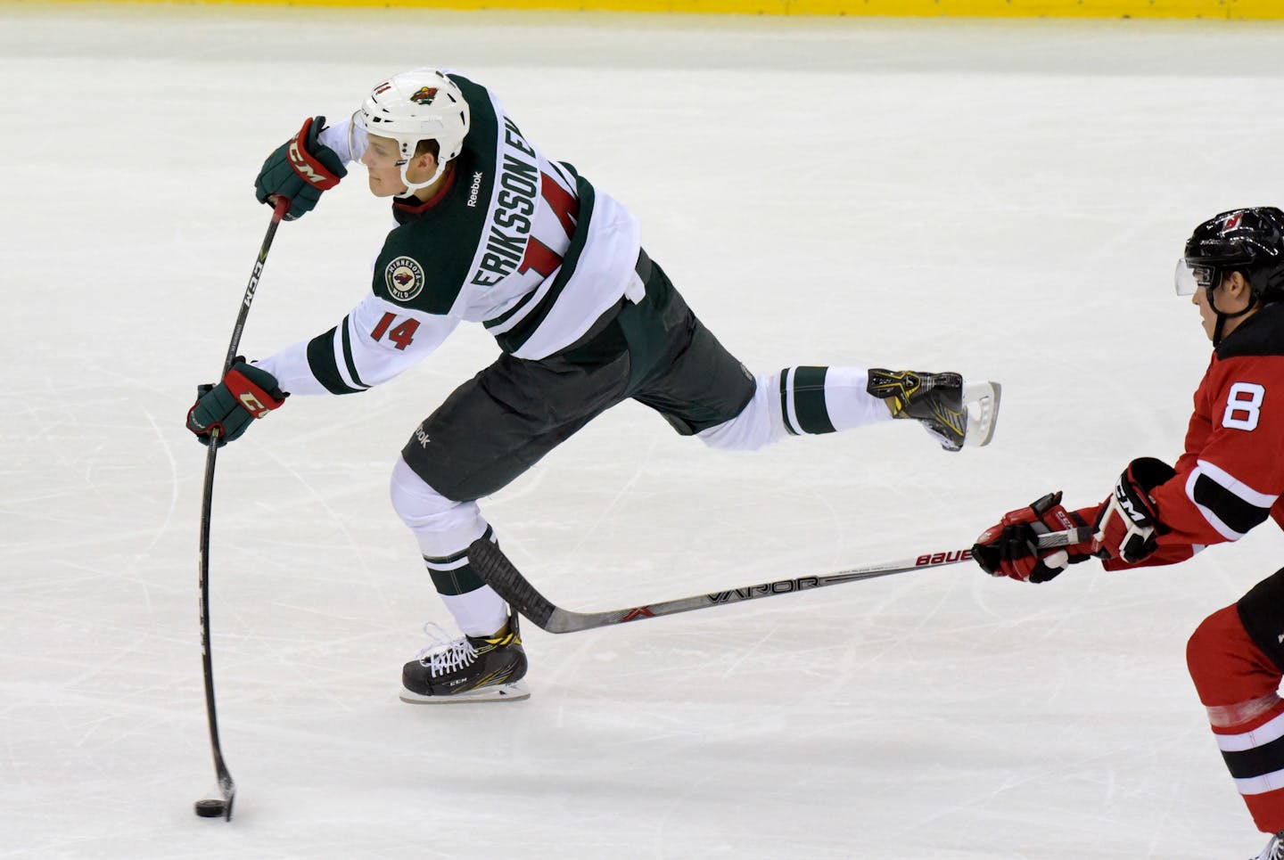 Minnesota Wild center Joel Ericsson El (14) shoots as New Jersey Devils right wing Beau Bennett looks on during the third period of an NHL hockey game Saturday, Oct. 22, 2016, in Newark, N.J. (AP Photo/Bill Kostroun)