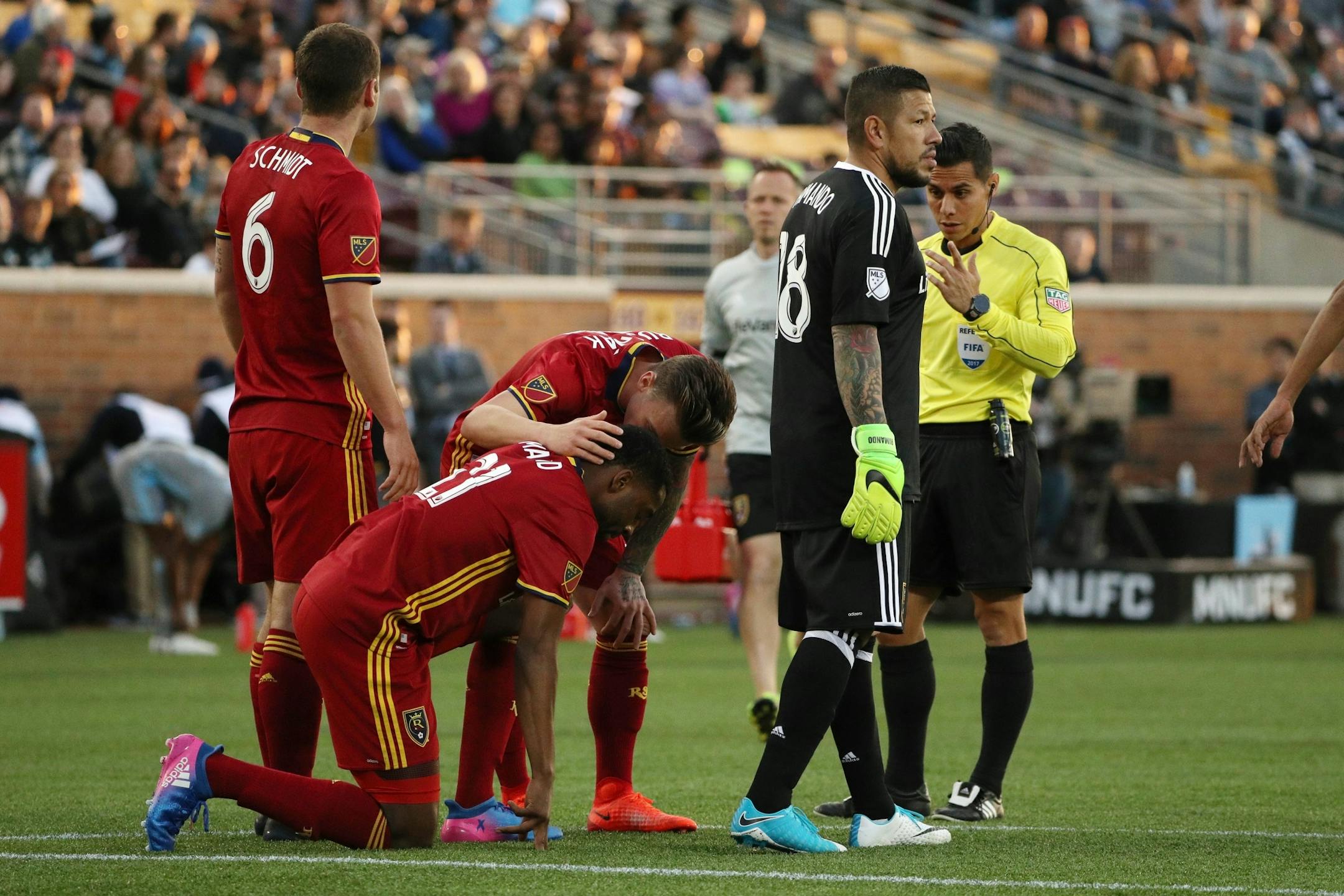 Real Salt Lake midfielder Albert Rusnak (11) checks on defender Aaron Maund (21) after he went down with an injury in the first half.