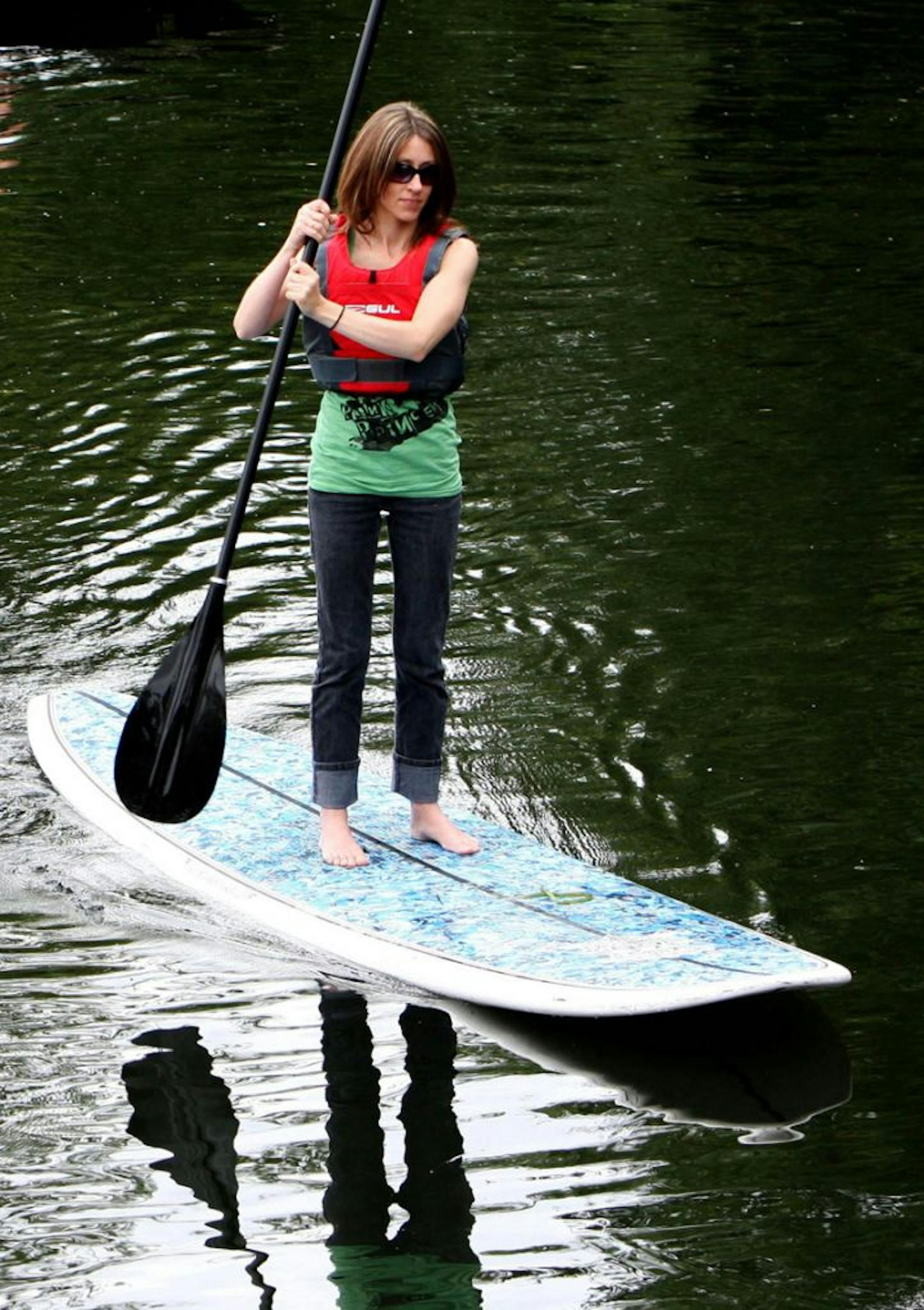 Paddle board instructor Rowland Gurner, left, and Nicola Stroud, right, take their paddle boards down the River Cam, past a punt, in Cambridge, England, Monday, Aug. 3, 2009. Paddle boards are a new alternative to the traditional method of cruising the river on a punt. Originally from Hawaii, paddle surfing requires no waves and is much easier to learn than surfing as it simply involves standing on a long super-stable board and propelling yourself using a long-bladed paddle.