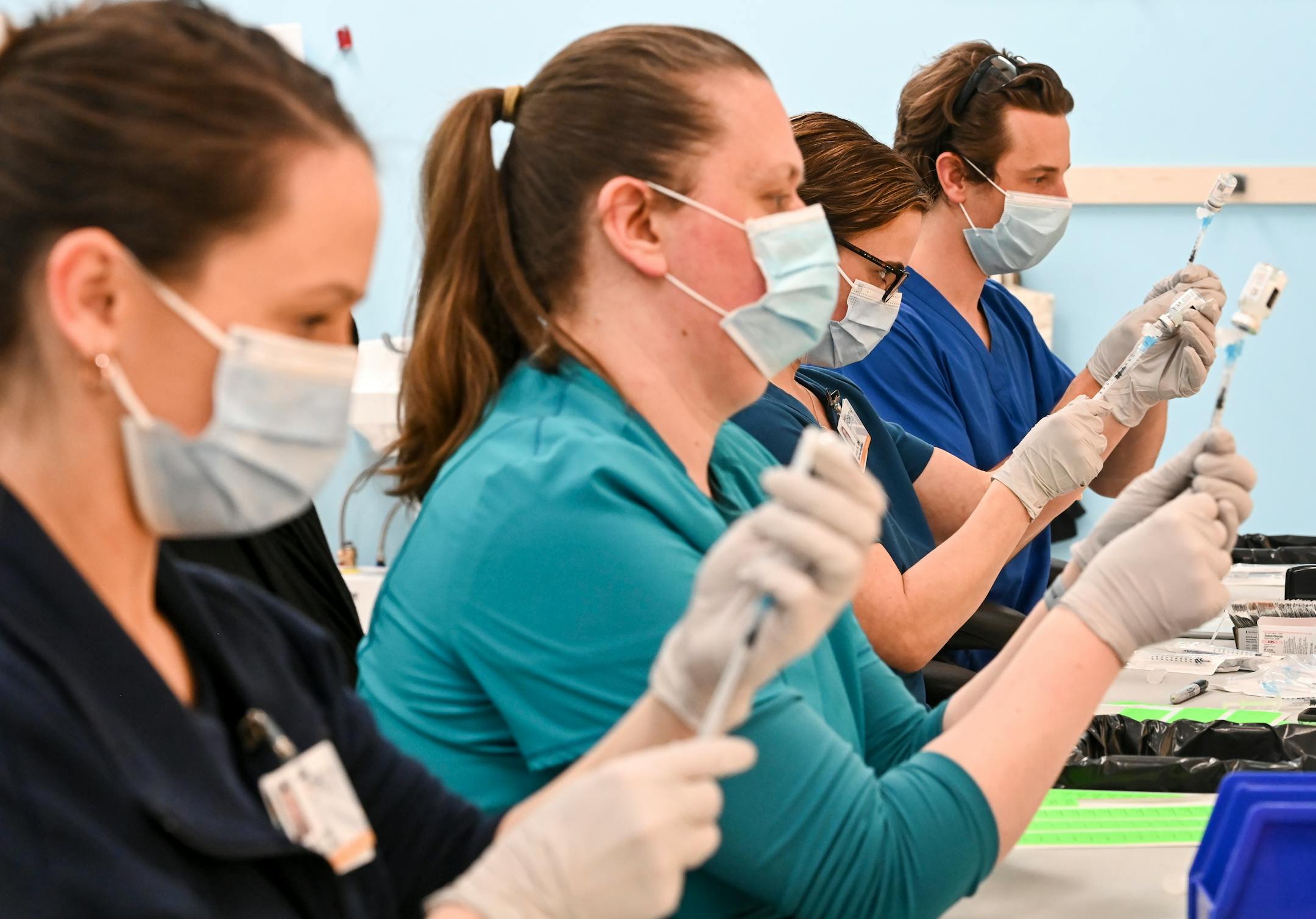 From left, Blue Cross and Blue Shield of Minnesota nurses Alison Stumne, Tamara Pierre, Jana Wagner and Kirk Randall filled syringes with the Moderna COVID-19 vaccine at a North Memorial Health Hospital vaccination clinic in Brooklyn Center.
