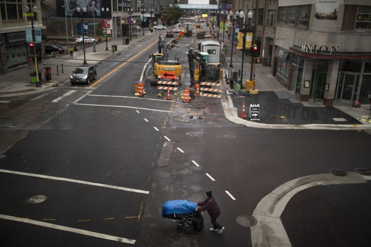 A pedestrian pushed a cart near the intersections of 8th &Hennepin Avenue .