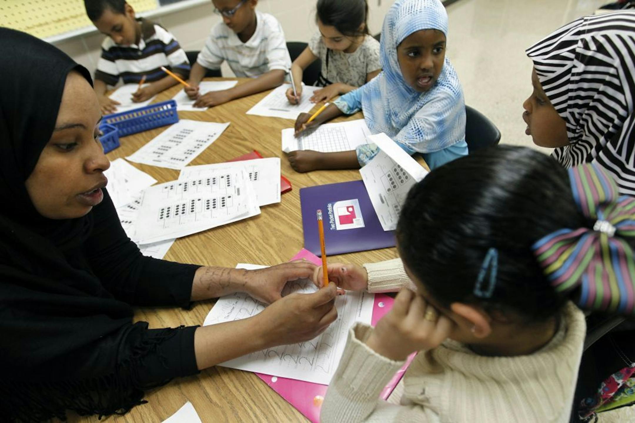 Teaching assistant Yasmin Mohammed helps future kindergardeners/first graders with some math exercises during summer school at Tarek ibn Ziyad Academy.