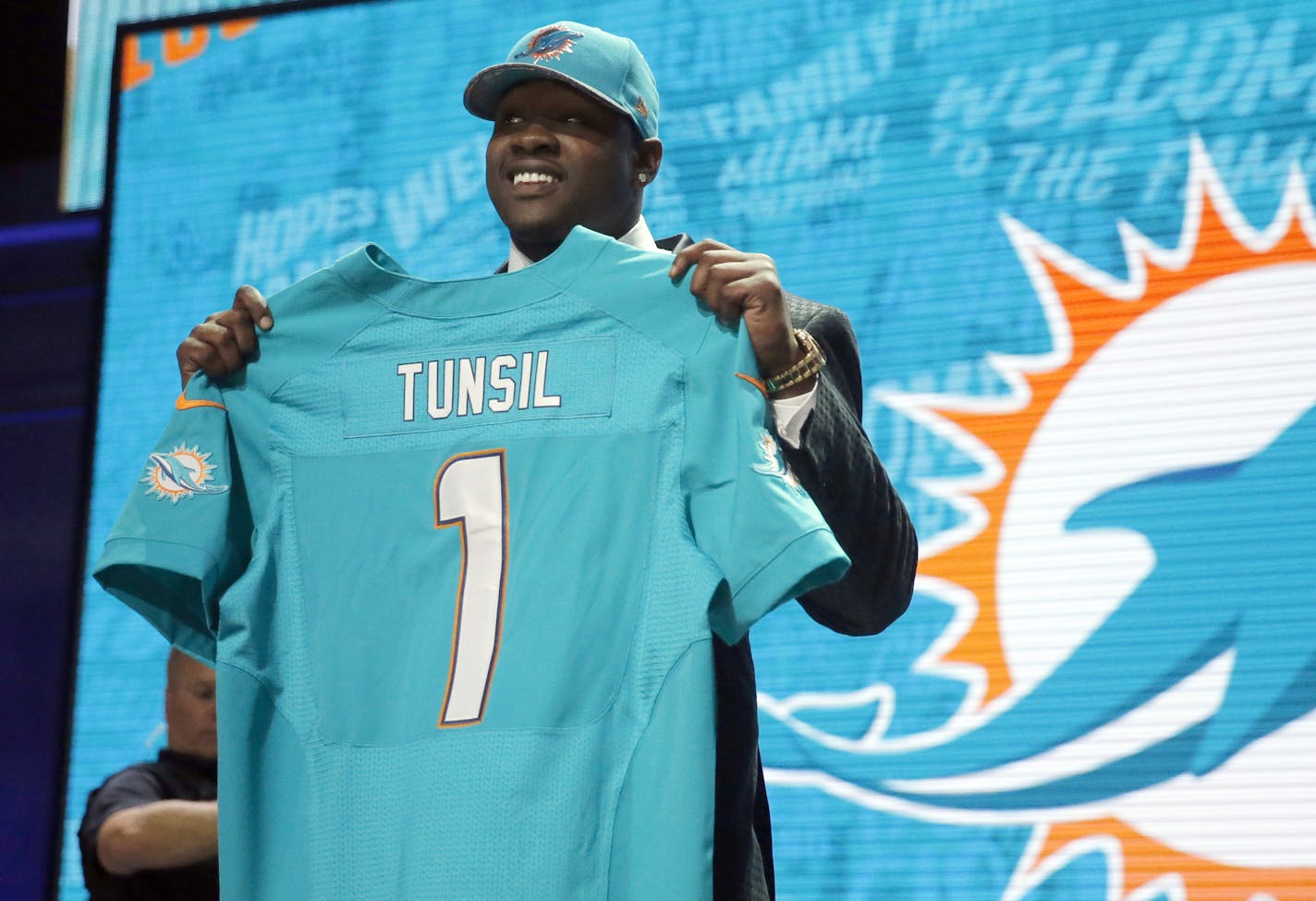 Mississippi&#x2019;s Laremy Tunsil poses for photos after being selected by the Miami Dolphins as the 13th pick in the first round of the 2016 NFL football draft, Thursday, April 28, 2016, in Chicago. (AP Photo/Charles Rex Arbogast)