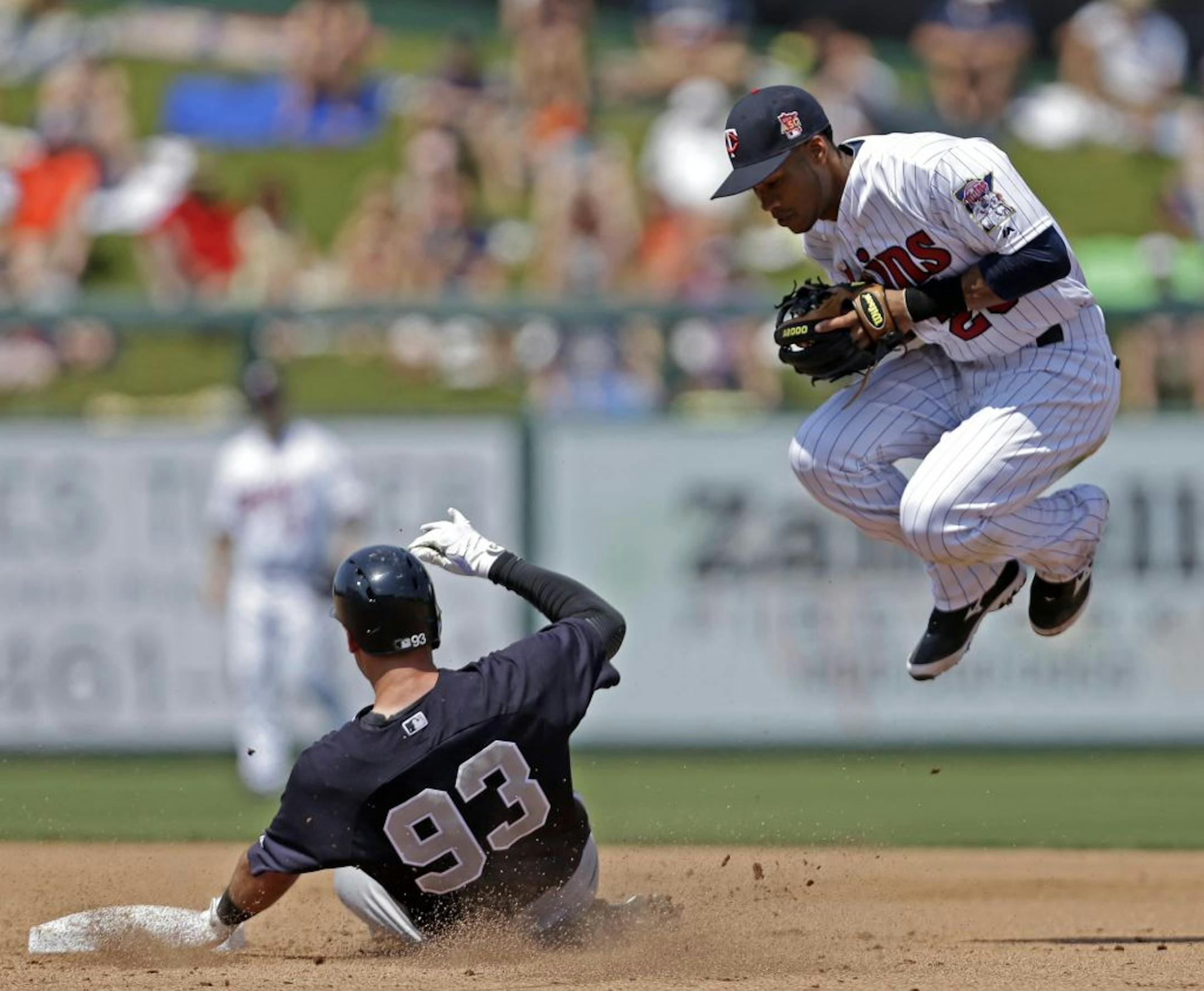 Minnesota Twins shortstop Pedro Florimon leaps out of the was a New York Yankees Dean Anna (93) is forced out at second on a grounder off the bat of Zoilo Almonte in the fourth inning of an exhibition baseball game in Fort Myers, Fla., Saturday, March 22, 2014.