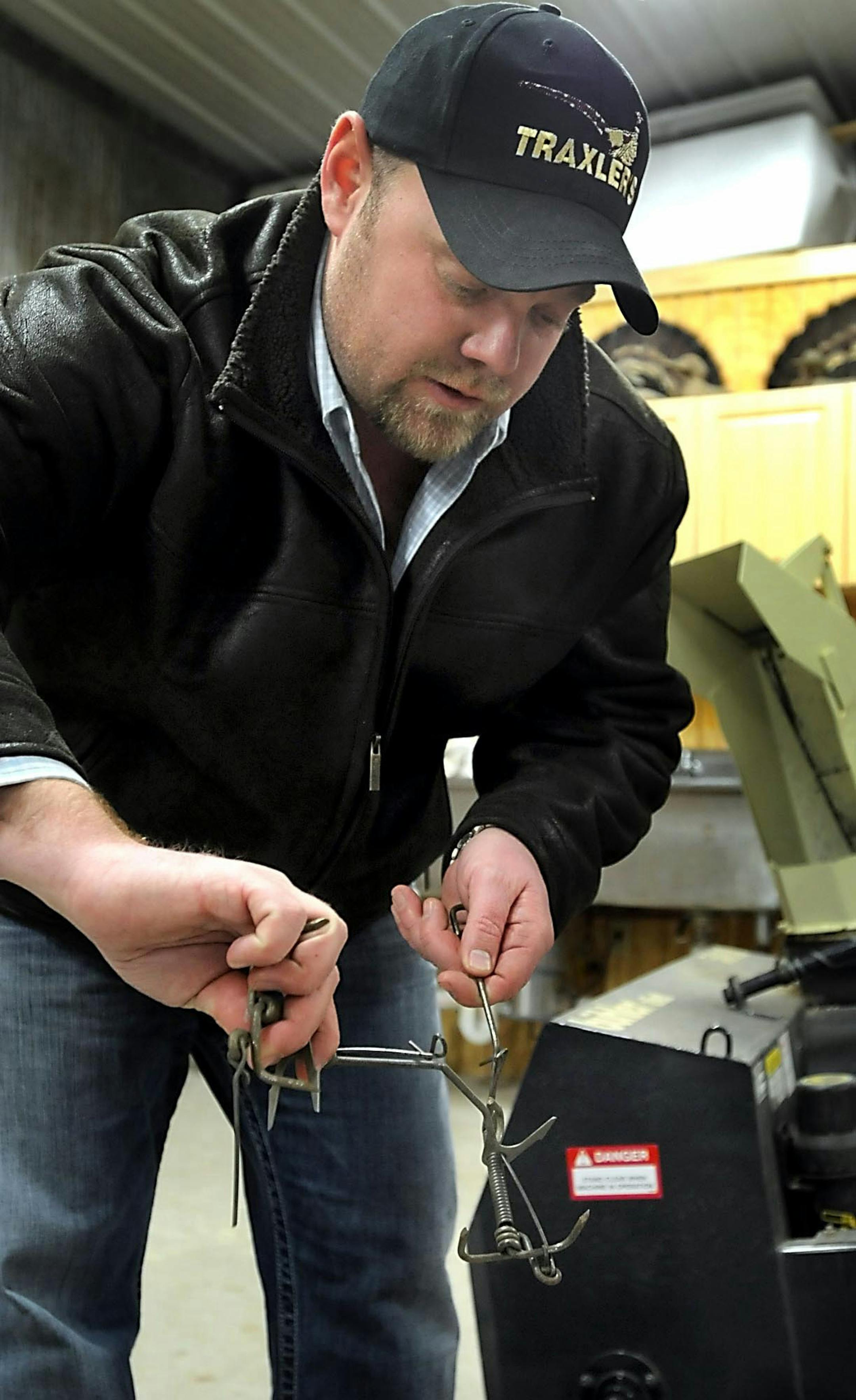 Marty Walgenbach demonstrates how a pocket gopher trap works in his shed near Mankato, Minn.