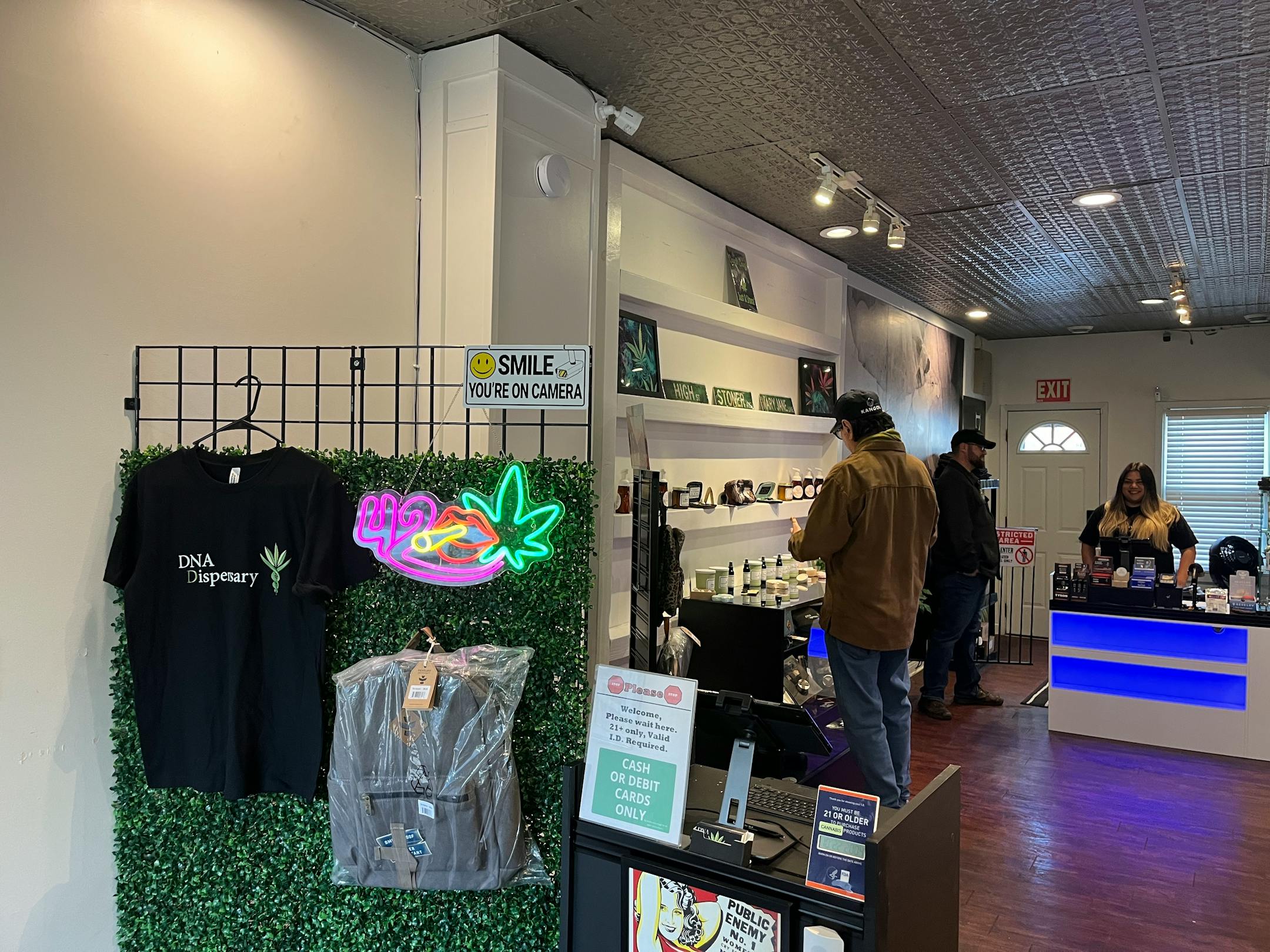 Alex Skym and Deedra Perron help a customer at DNA Dispensary in St. Paul. Beyond cannabis products, there are t-shirts and bags for sale.