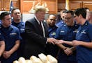 President Donald Trump is presented with a challenge coin as he meets with members of the U.S. Coast Guard stationed at United States Coast Guard Stat