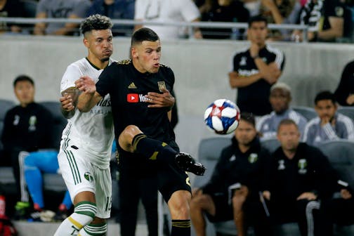 Los Angeles FC forward Christian Ramirez, right, and Portland Timbers defender Julio Cascante fight for the ball during the first half of a U.S. Open Cup quarterfinals soccer match in Los Angeles, Wednesday, July 10, 2019. (AP Photo/Ringo H.W. Chiu) ORG XMIT: CARC105