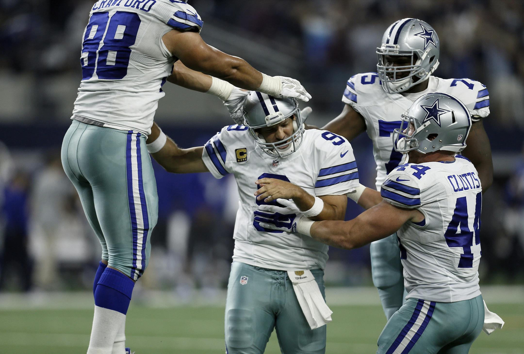 Dallas Cowboys quarterback Tony Romo (9), defensive tackle Tyrone Crawford (98), tackle Darrion Weems (75) and fullback Tyler Clutts (44) celebrate a last minute touchdown pass to tight end Jason Witten (82) to win against the New York Giants during the second half of an NFL football game Sunday, Sept. 13, 2015, in Arlington, Texas. Cowboys won 27-26. (AP Photo/Brandon Wade) ORG XMIT: CBS184