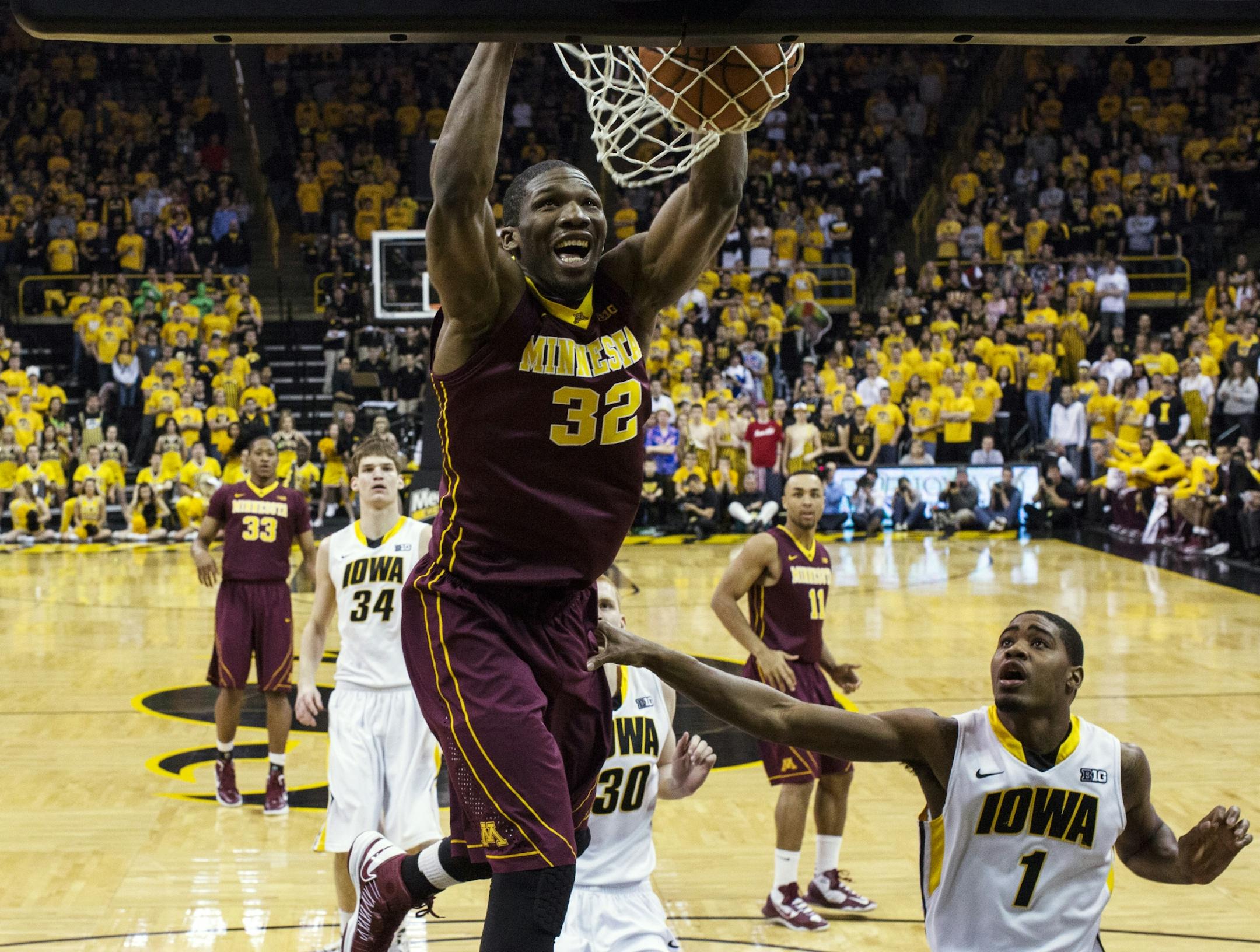 Minnesota forward Trevor Mbakwe (32) dunks over Iowa forward Melsahn Basabe (1) during the first half of an NCAA college basketball game, Sunday, Feb. 17, 2013, in Iowa City, Iowa.