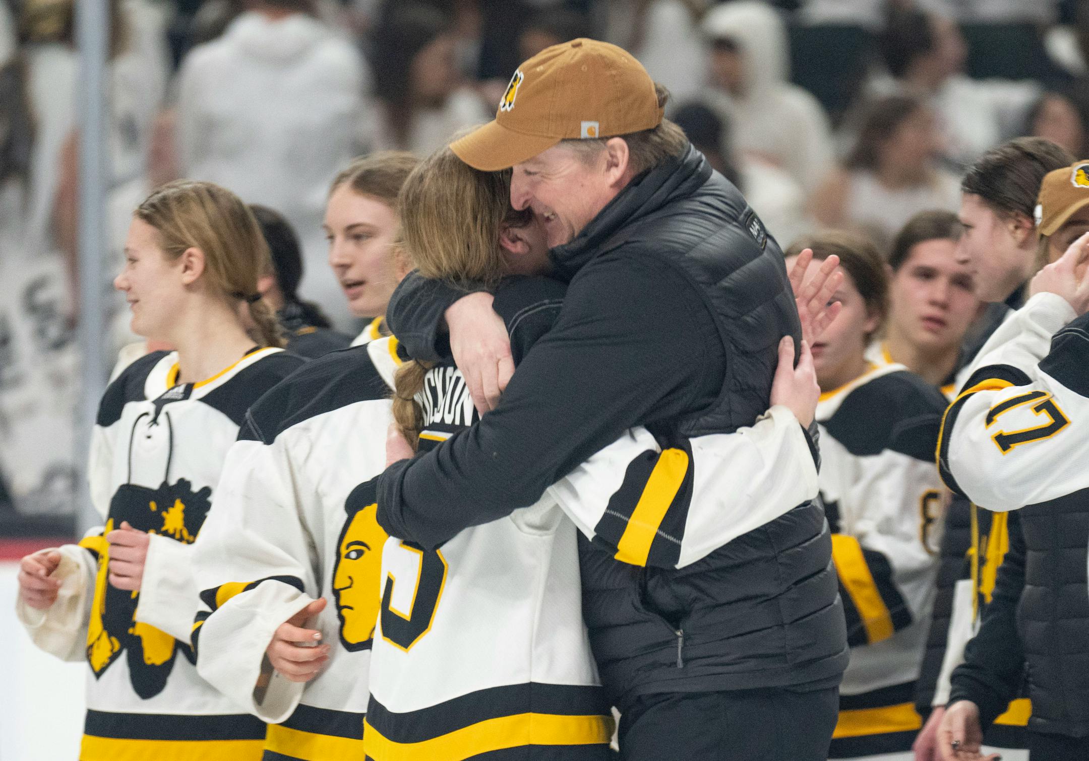 Warroad forward Talya Hendrickson (13) embraces head coach David Marvin after defeating Orono 3-1 to win the Class 1A girl's hockey championship.