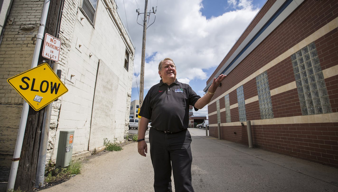 Steve Williams, owner of Bobby and Steve's Auto World in downtown Minneapolis, shows the drive that they would like to expand by demolishing the white building on the left on Friday, August 7, 2015. ] LEILA NAVIDI leila.navidi@startribune.com / BACKGROUND INFORMATION: The most prominent gas station near downtown Minneapolis wants to make it easier for cars to drive in and out of their property, but a 123-year-old relic of Minneapolis' Swedish cultural history is standing in the way. City staff h