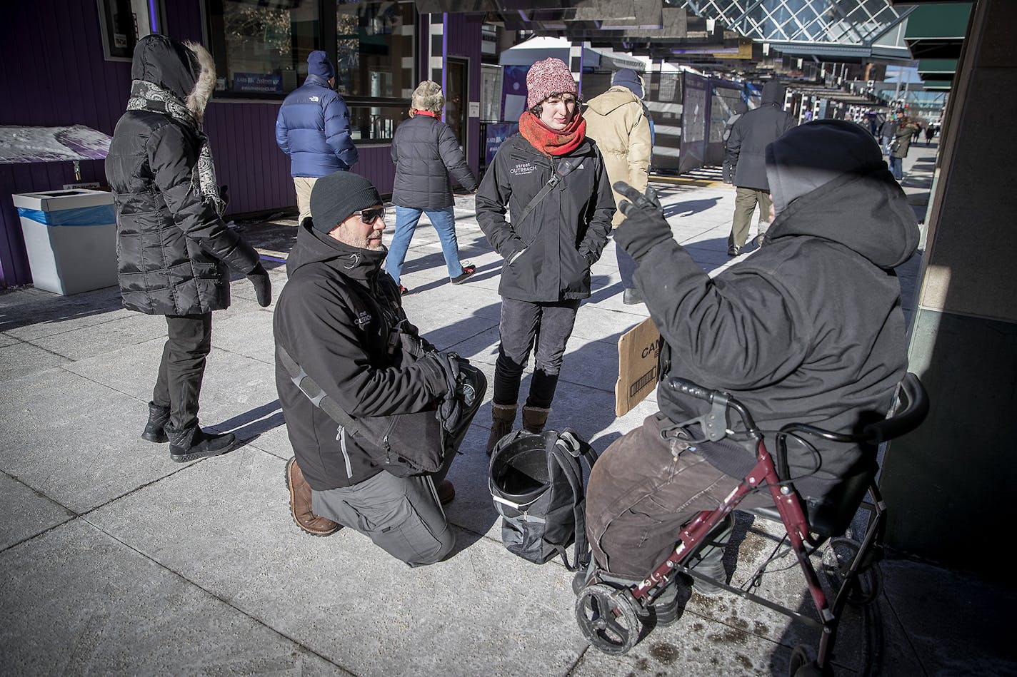 John Tribbett, left, and Ilana Budenosky, cq, with the St. Stephen's Street Outreach met with a man who was panhandling along Nicollet Mall, Thursday, January 1, 2018 in Minneapolis, MN.