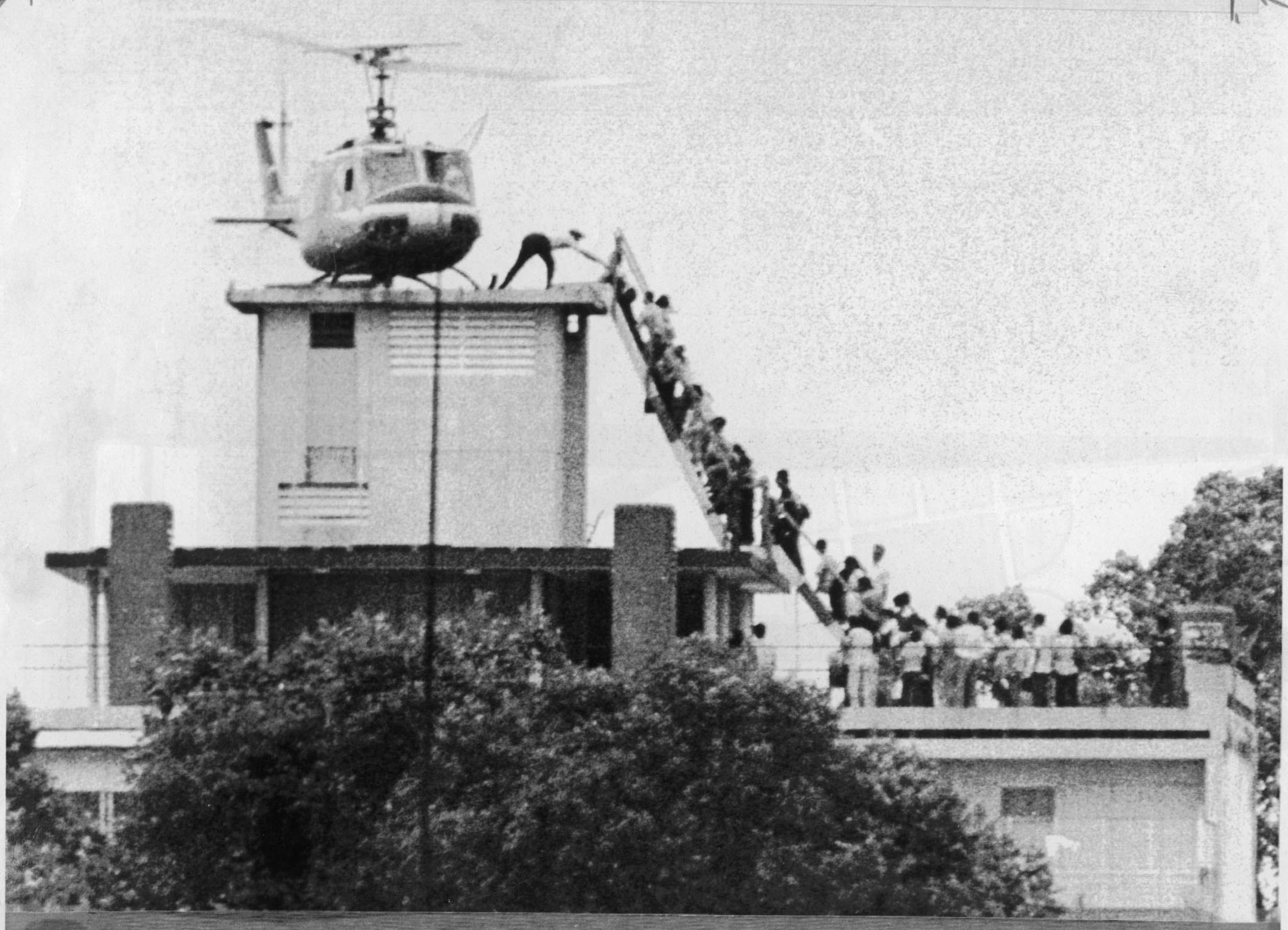 April 29, 1975 -- An Air America helicopter crew member helps evacuees up a ladder on top of a building in Saigon to to be taken by helicopter to Navy ships waiting off the coast as North Vietnamese troops approached. United Press International (UPI) file photo.