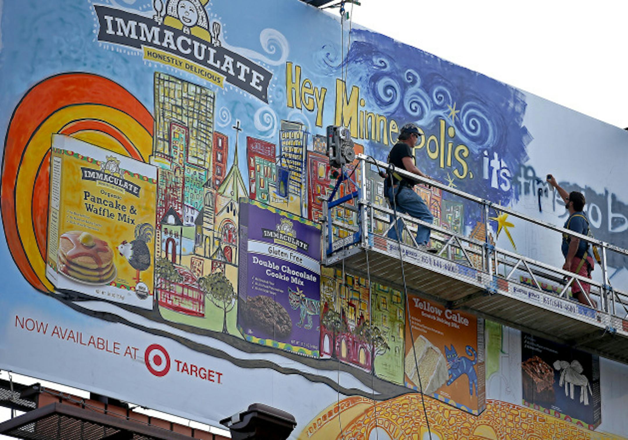 Mixed-media artist Andy Saczynski worked on a billboard in downtown Minneapolis, Thursday, August 7, 2014.  Saczynski is painting the  billboard 60-feet above 930 Hennepin (former National Camera building) to celebrate Immaculate Baking Company's new line of scratch baking mixes and ingredients.  He specializes in assemblage art and works primarily in acrylic and found objects as well as recycled and reclaimed items.    ] (ELIZABETH FLORES/STAR TRIBUNE) ELIZABETH FLORES ' eflores@startribune.com
