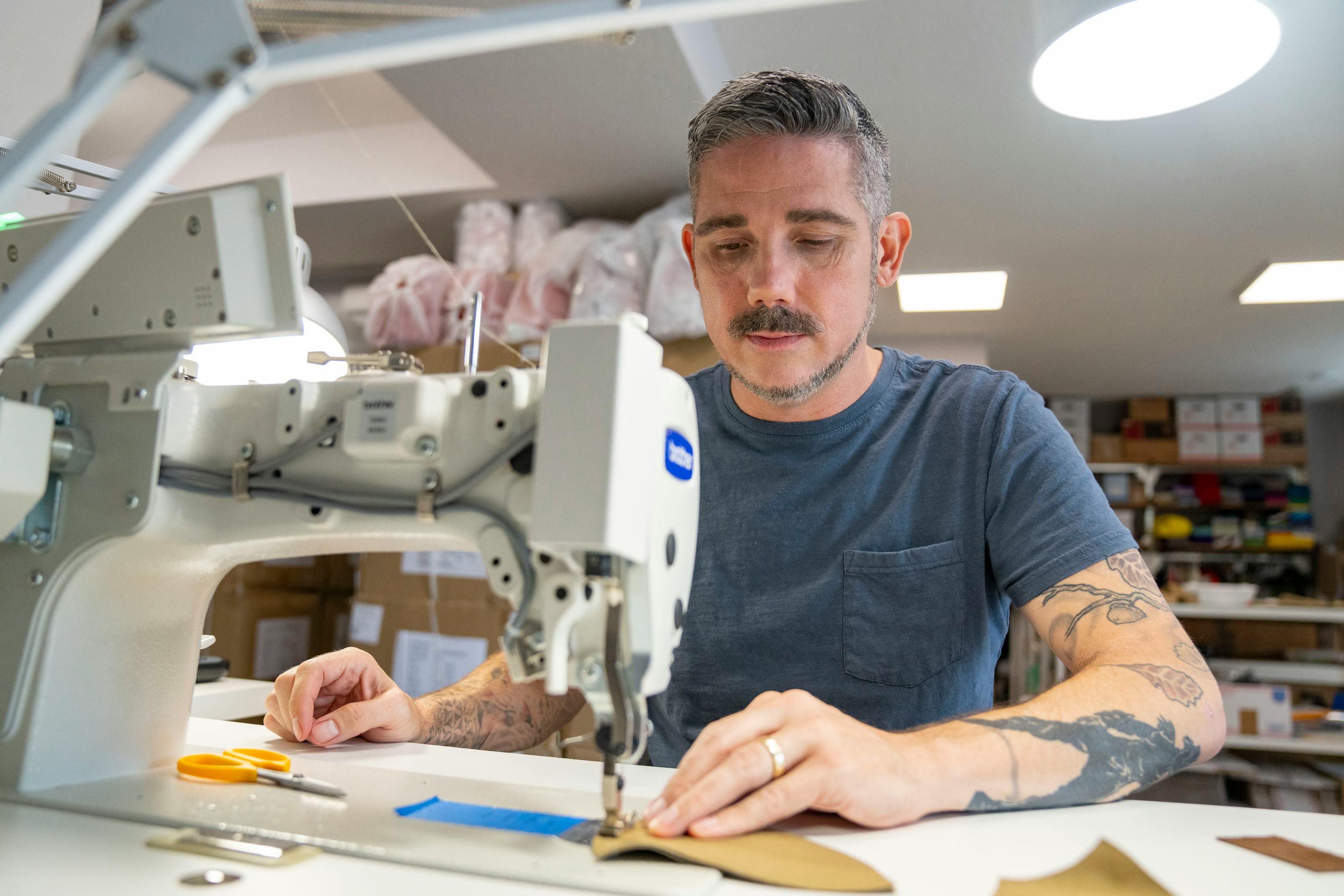 Christopher Straub using a sewing machine.