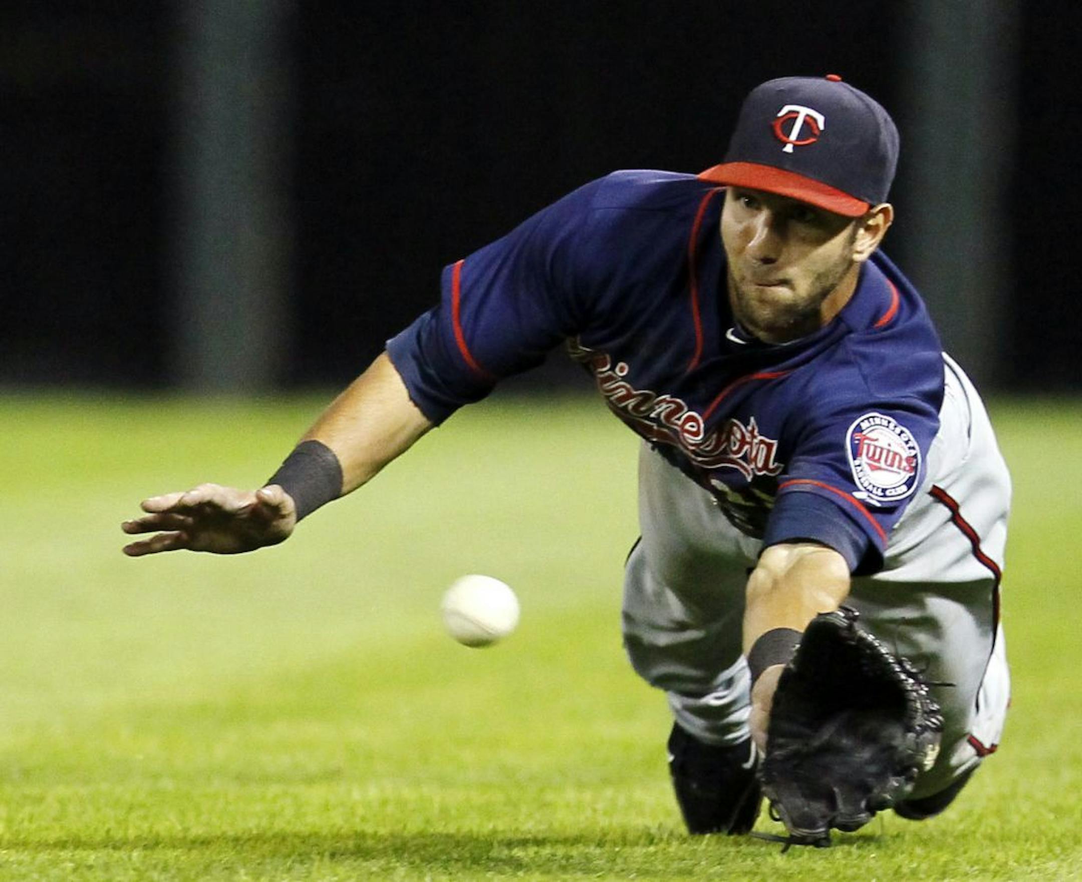 Minnesota Twins right fielder Darin Mastroianni makes a play on a fly ball by Chicago White Sox's Alejandro De Aza that was first called a trap, then over turned by a conference of umpires to a catch, during the seventh inning of a baseball game, Tuesday, July 24, 2012, in Chicago.