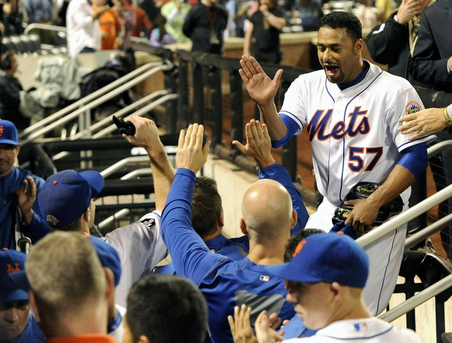 New York Mets starting pitcher Johan Santana (57) high-fives teammates at the dugout after throwing a no-hitter against the St. Louis Cardinals in a baseball game on Friday, June 1, 2012, at Citi Field in New York. The Mets won 8-0.