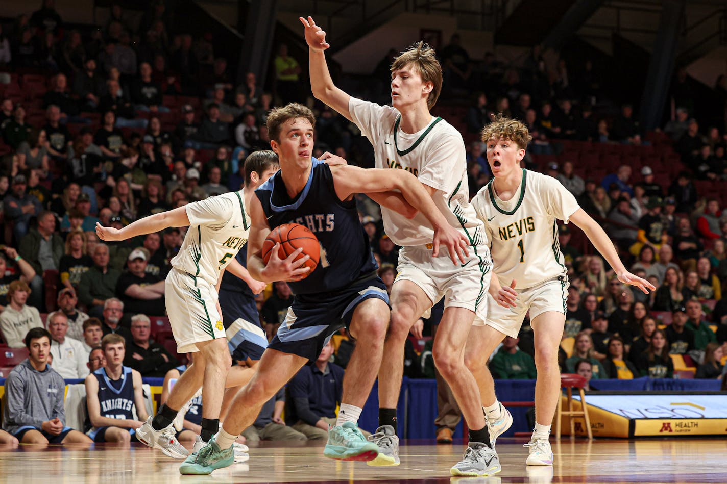 Aiden Wichmann (14) of Russell-Tyler-Ruthton twisted his way out from the defense of Nevis' Alex Lester in the second half. Wichmann scored 24 points in an 80-62 R-T-R victory. Class 3A boys basketball Class 1A state tournament quarterfinal, Nevis vs. Russell-Tyler-Ruthton at Williams Arena, 3-16-23. Photo by Mark Hvidsten, SportsEngine