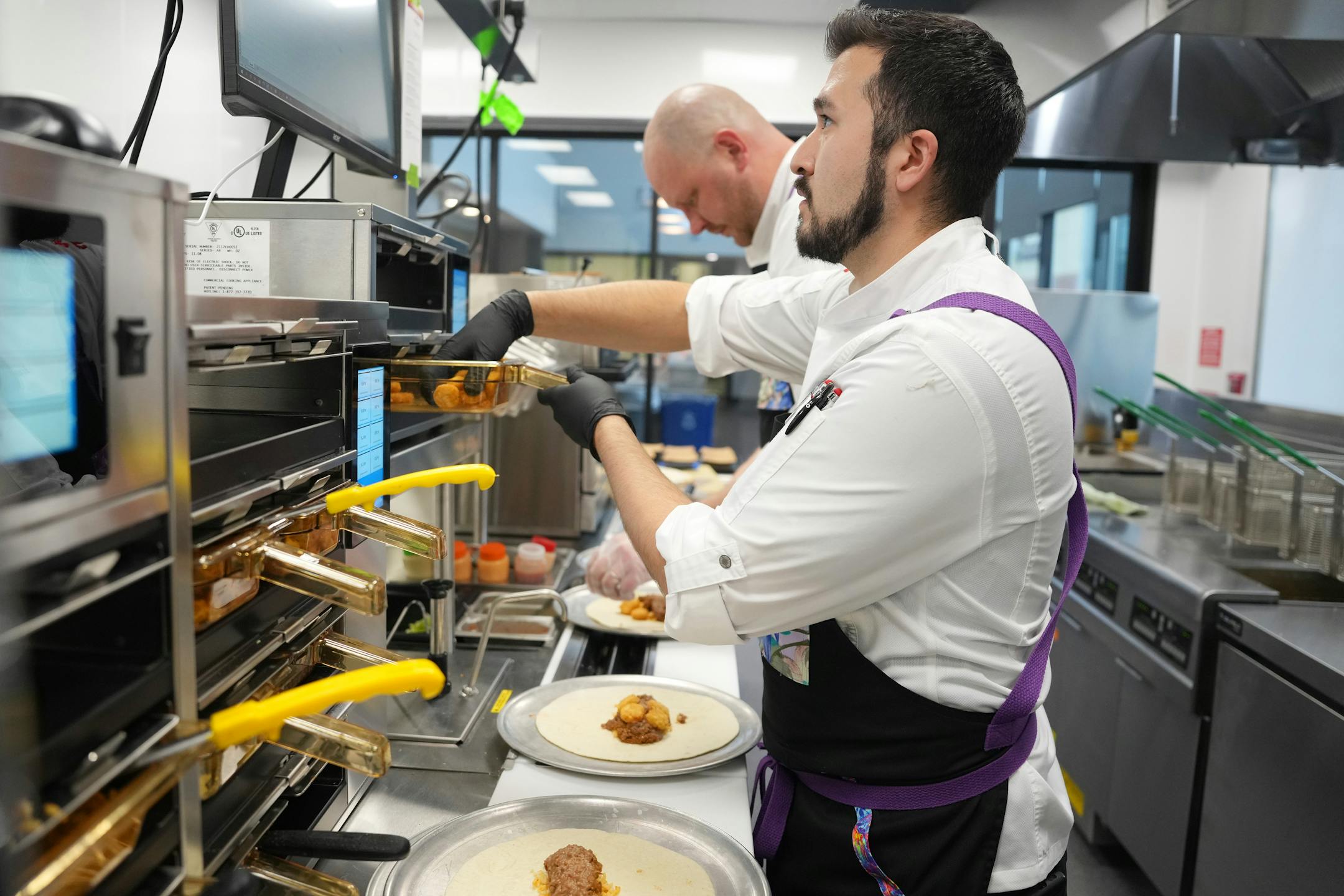 Taco John's senior manager of quality assurance Brando Tijerina and culinary assistant Andy Cook prepare for an executive team menu showing.