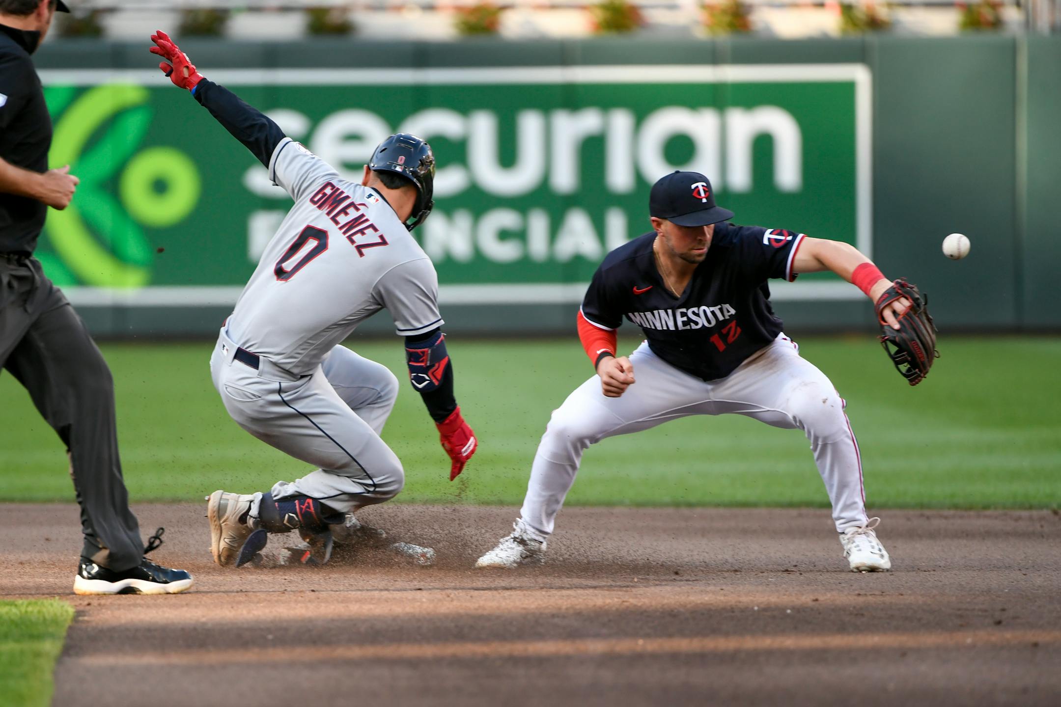 Cleveland Guardians' Andres Gimenez (0) is safe at second after hitting a double before Minnesota Twins shortstop Kyle Farmer (12) can make a tag during the fourth inning of a baseball game, Saturday, June 3, 2023, in Minneapolis. (AP Photo/Craig Lassig)