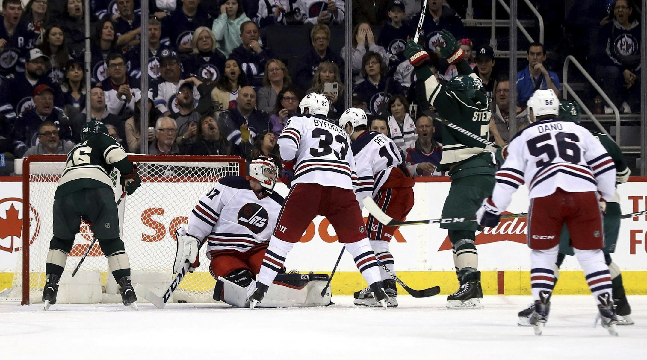 Minnesota Wild's Chris Stewart (7), right, celebrates after scoring against Winnipeg Jets goaltender Connor Hellebuyck (37) during second-period NHL hockey game action in Winnipeg, Manitoba, Sunday, March 19, 2017.