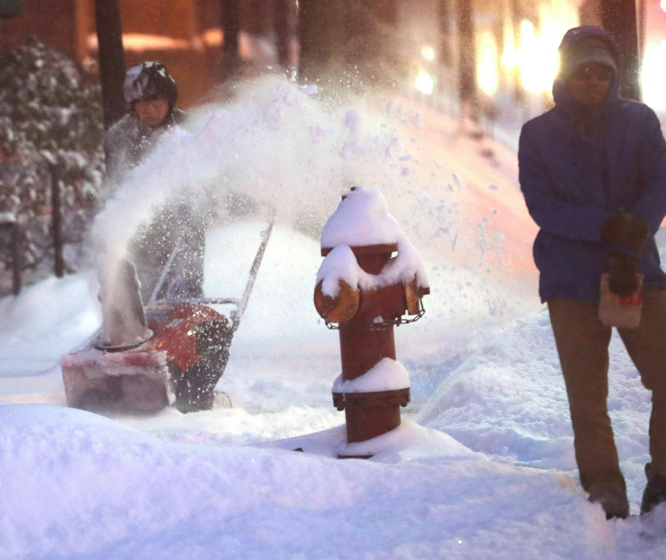 Maintenance person Phillip Garza blows snow in front of a group of apartments Tuesday in Minneapolis. It was Garza's first time with a new snow thrower.