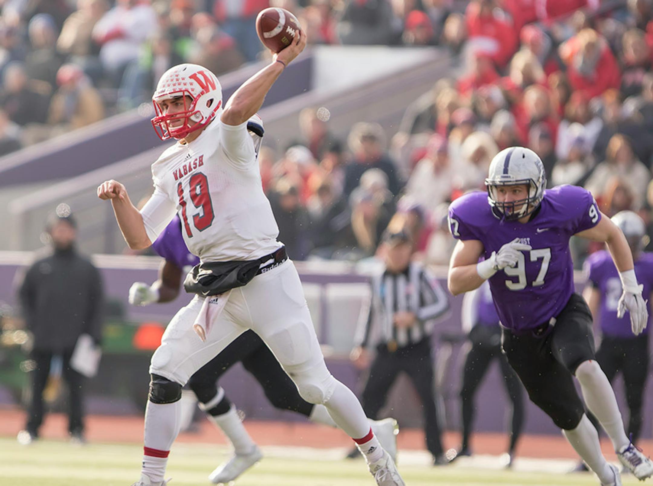 \w19 throws the ball with St. Thomas defensive lineman Jack Newell (97) in pursuit as the University of St. Thomas Tommies hosted the Wabash College Little Giants on December 5, 2015.