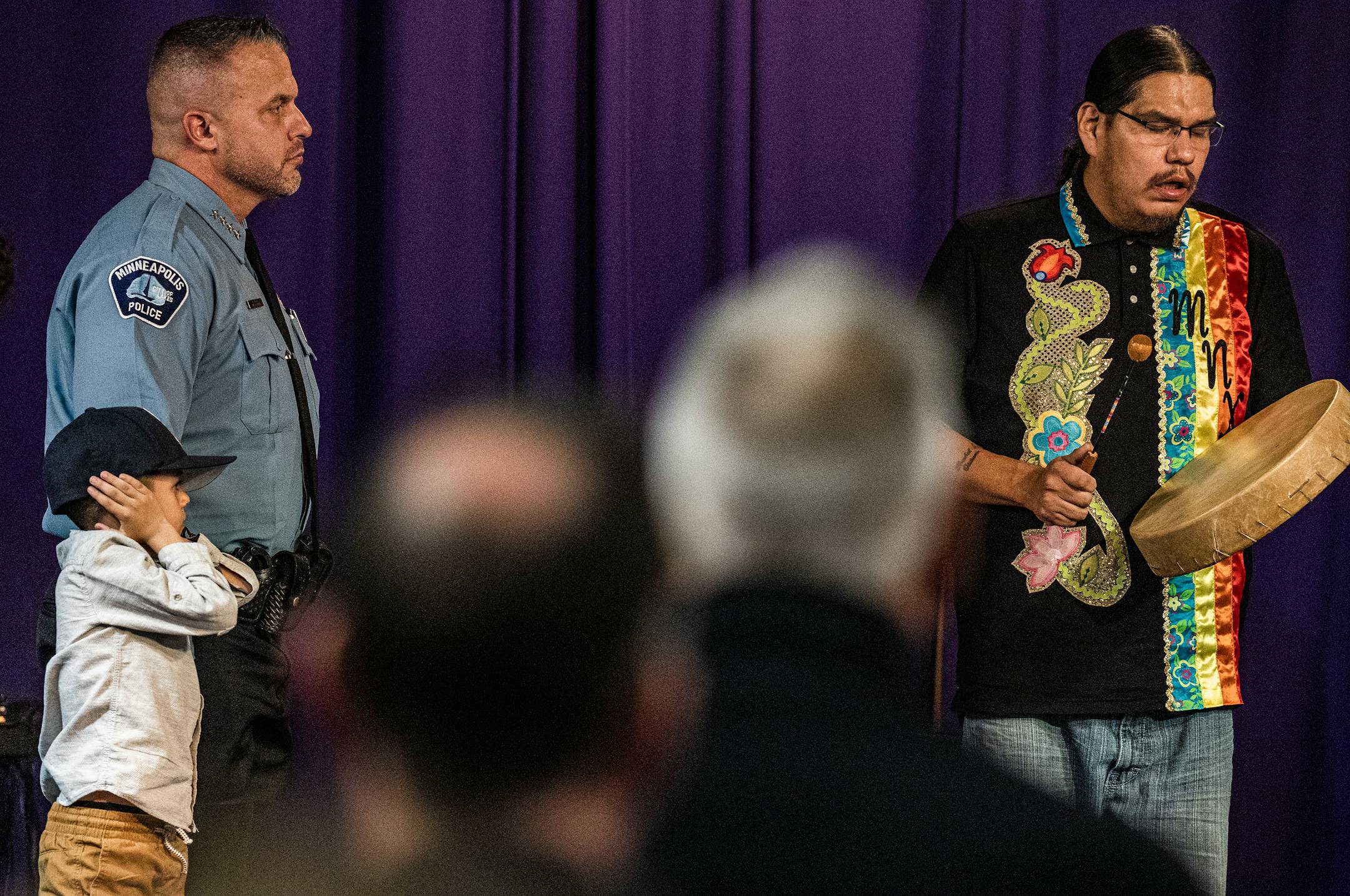Brian O'Hara stands with son Seamus, 6, as the Little Earth Drummers plays for the new Minneapolis Chief of Police at Shiloh Temple.