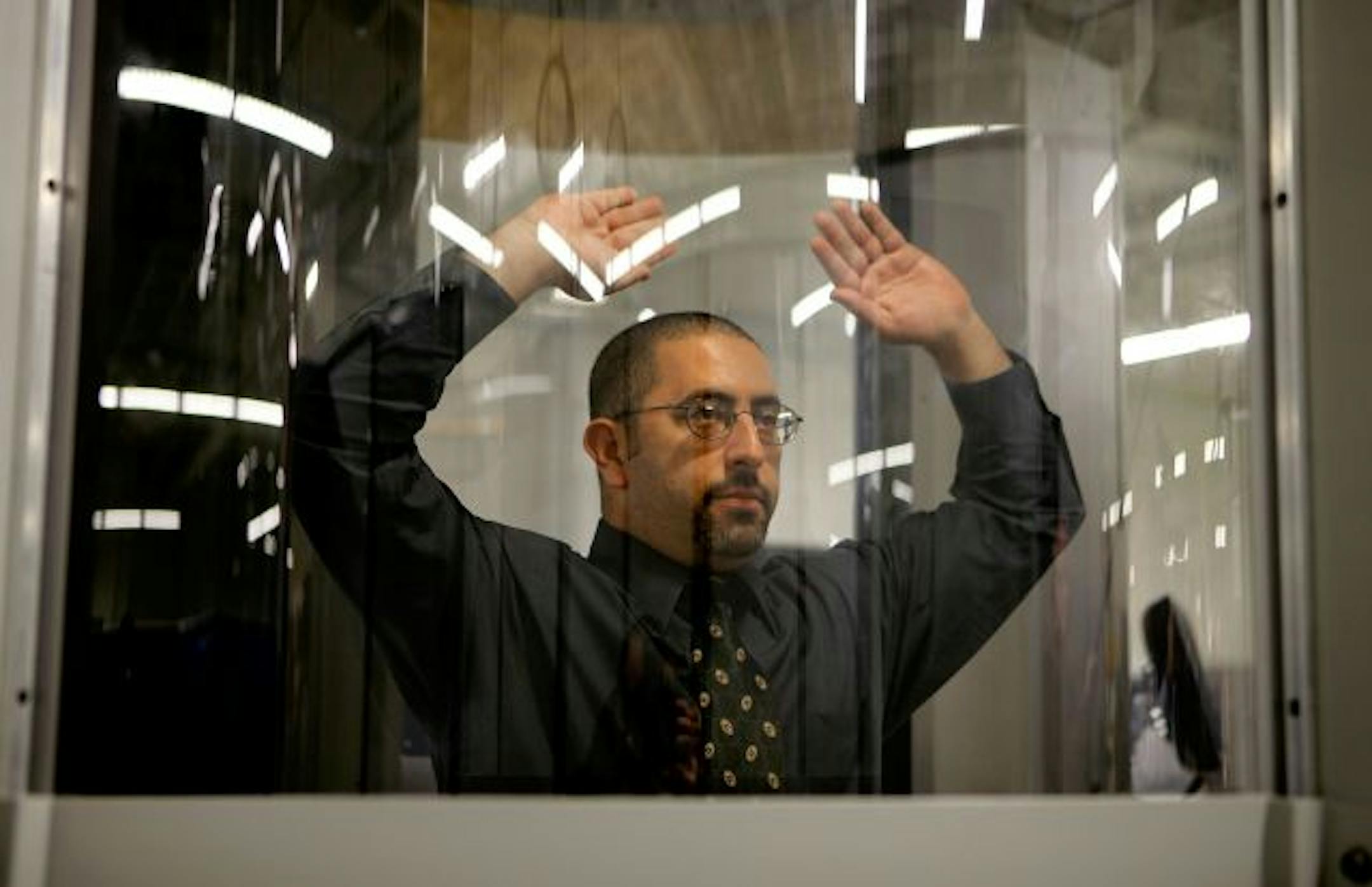 ARLINGTON, VA - DECEMBER 30: A volunteer stands inside a "millimeter wave" scanner during a demonstration at the Transportation Security Administration's Systems Integration Facility at Ronald Reagan National Airport December 30, 2009 in Arlington, Virginia. "Millimeter wave" passes electromagnetic waves over the body to create three-dimensional images that look like a photo negative. The scan can detect hidden metallic and nonmetallic objects such as weapons and explosives without physical cont