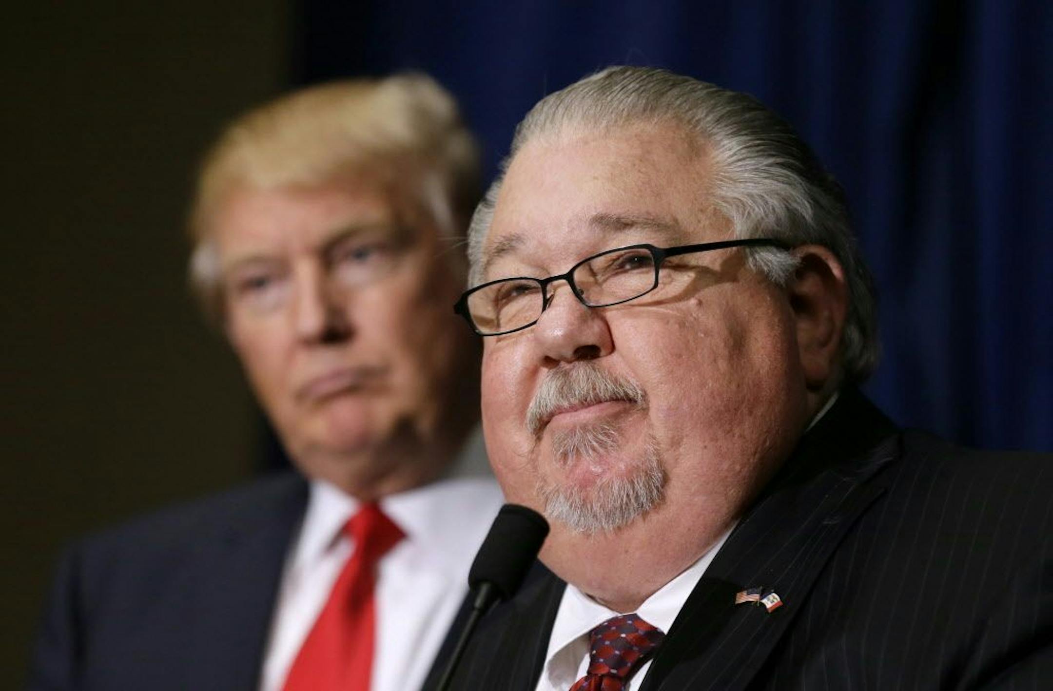 FILE - In this Aug. 25, 2016, file photo, Sam Clovis speaks during a news conference as then-Republican presidential candidate Donald Trump, left, watches before a campaign rally in Dubuque, Iowa. Clovis, a former Trump campaign official who has been linked to the investigation by special counsel Robert Mueller, has withdrawn his nomination for an Agriculture post.