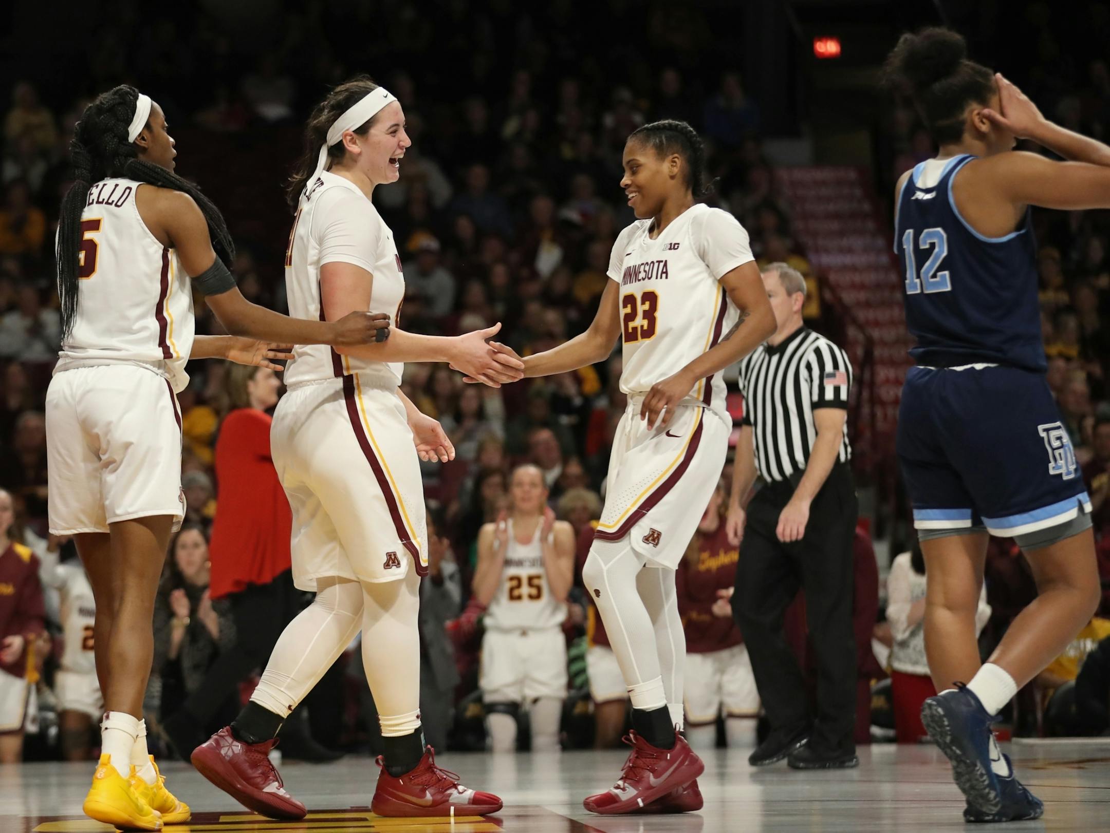 Gophers Taiye Bello (5), Annalese Lamke (41) and Kenisha Bell (23) gathered after a foul in the second half.