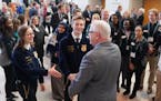 Governor Tim Walz talked with Future Farmers of America Minnesota state secretary Elaine Dorn and state president Lafe Arsvold before speaking at the 