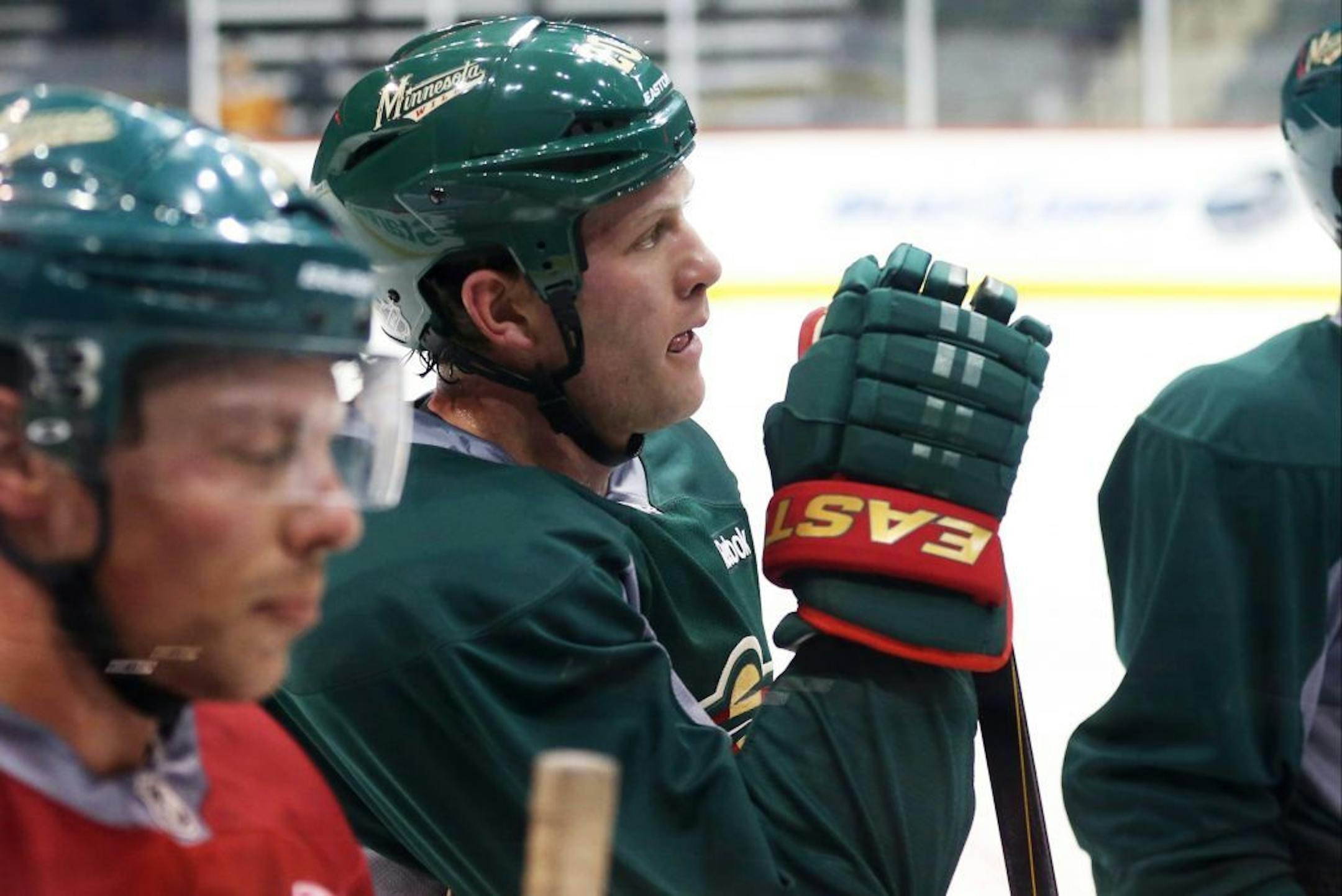 Minnesota Wild hockey players Darroll Powe, left, and Ryan Suter listen during instructions as a number of Wild players returned to the Xcel Energy Center for an informal workout
